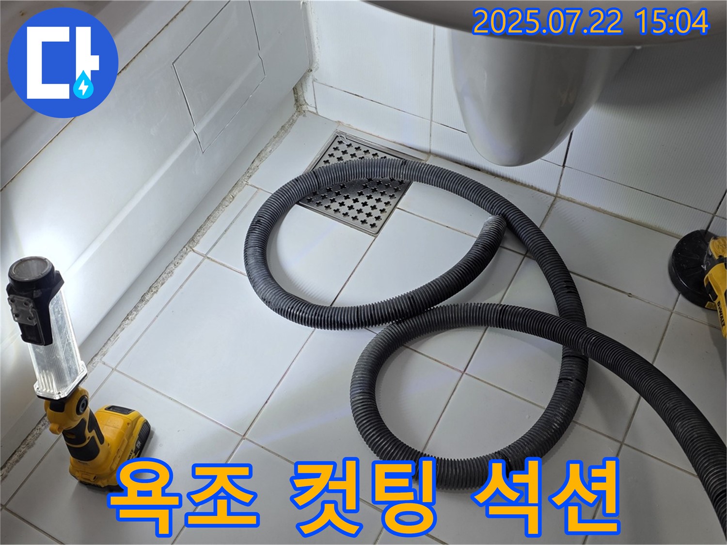 욕조 옆면을 컷팅하고 석션 장비로 물을 제거하는 누수 탐지 작업 모습