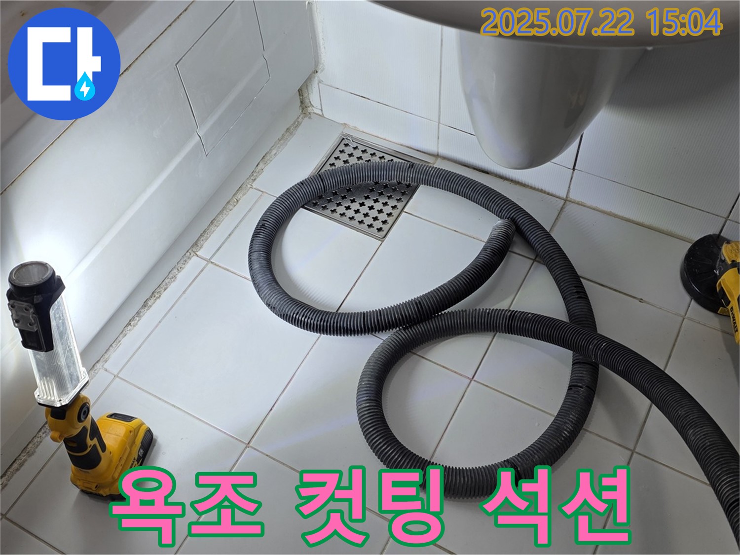 욕조 옆면을 컷팅하고 석션 장비로 물을 제거하는 누수 탐지 작업 모습