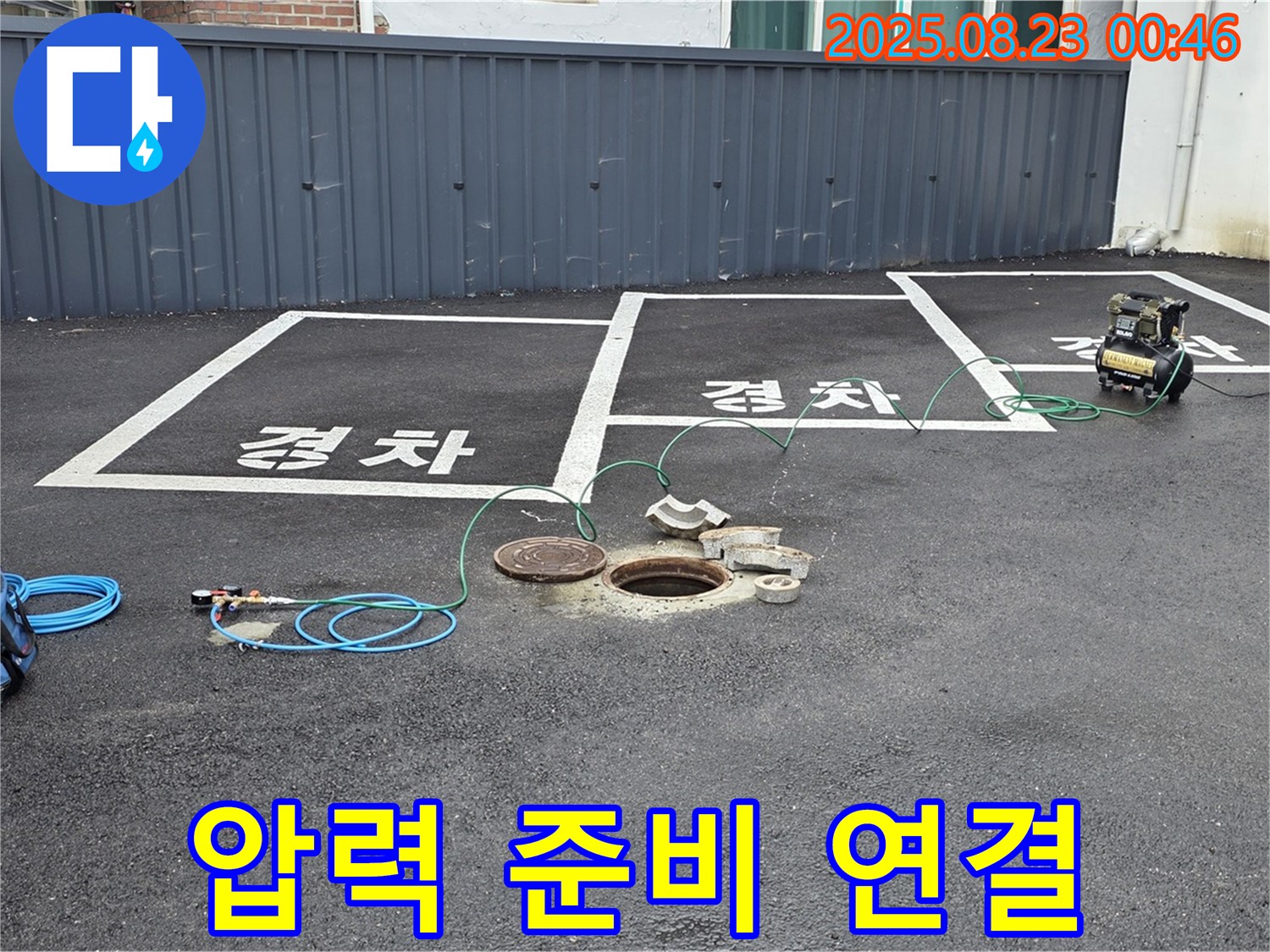 와수리 주차장 맨홀 누수 - 압력 검사를 위해 꼼꼼하게 장비를 연결하고 있습니다.