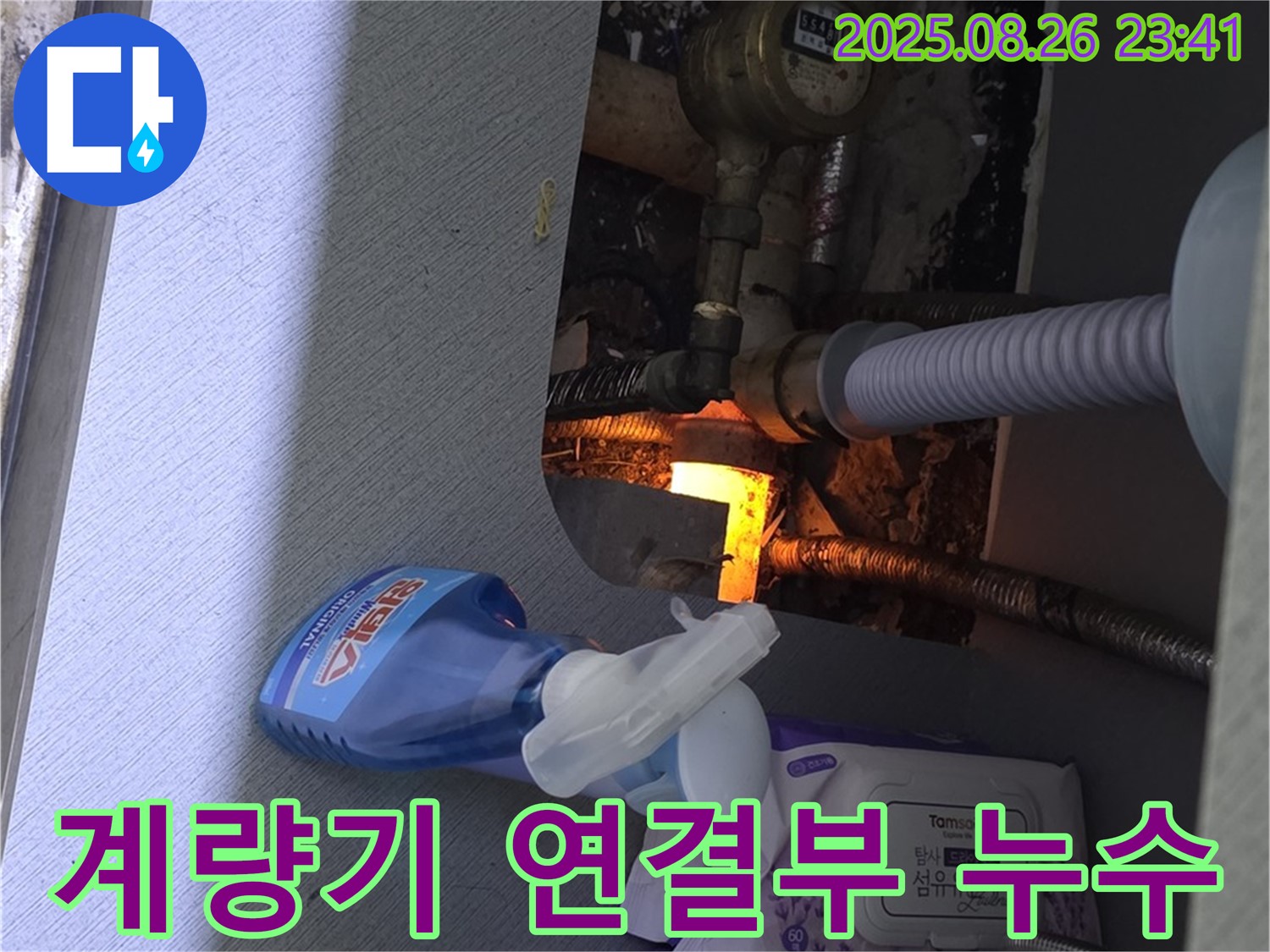 세면대 하부장 수도 계량기 연결부 누수 - 연결 부위를 집중적으로 확인하고 있습니다.