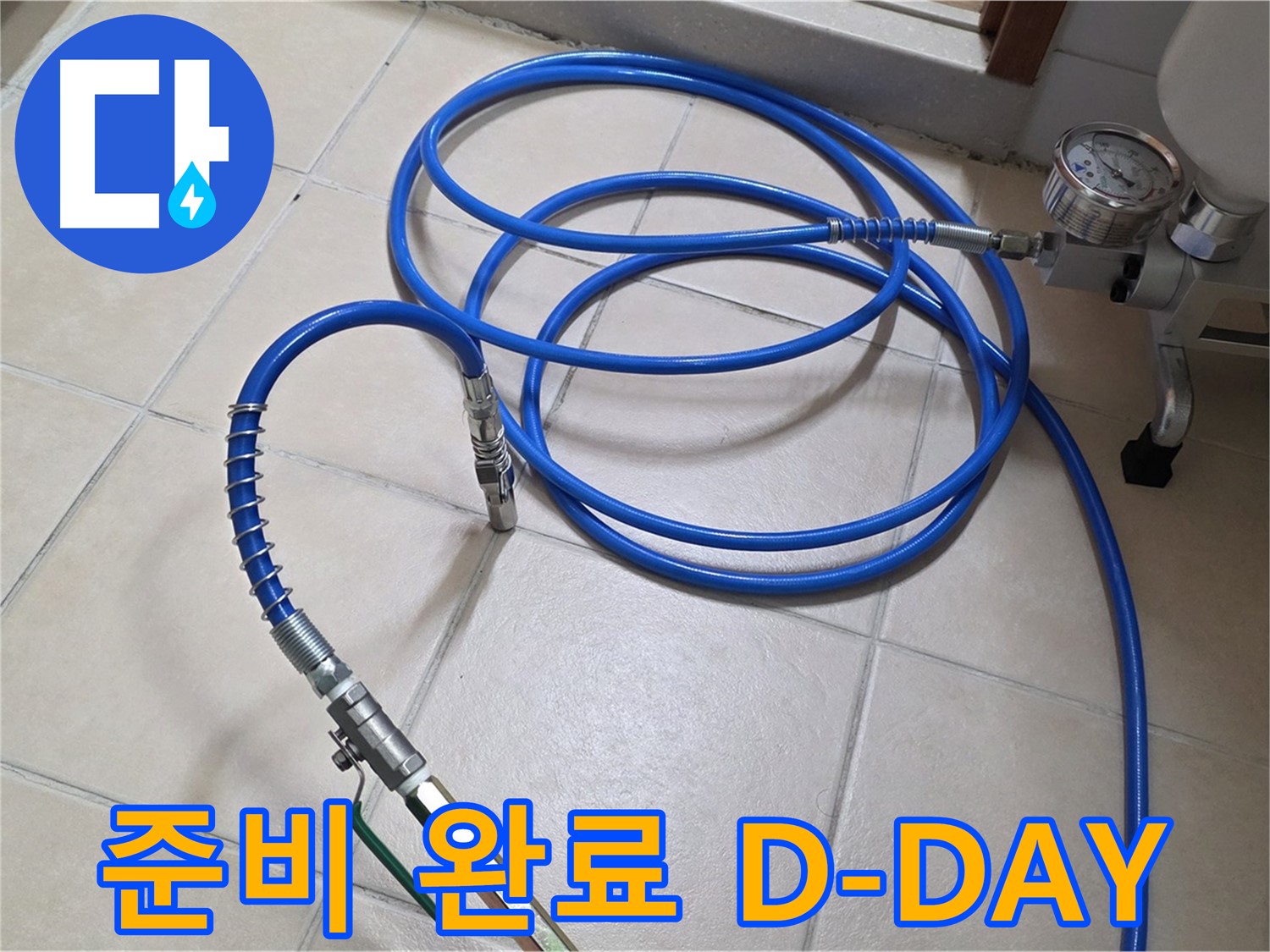 화장실 타일 바닥에 놓인 파란색 공기압 테스트용 호스와 게이지 장비