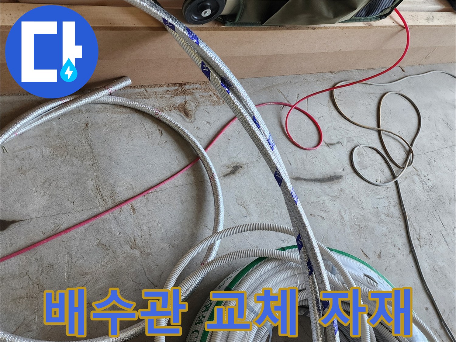 작업 현장 바닥에 놓인 배관용 호스와 전선들