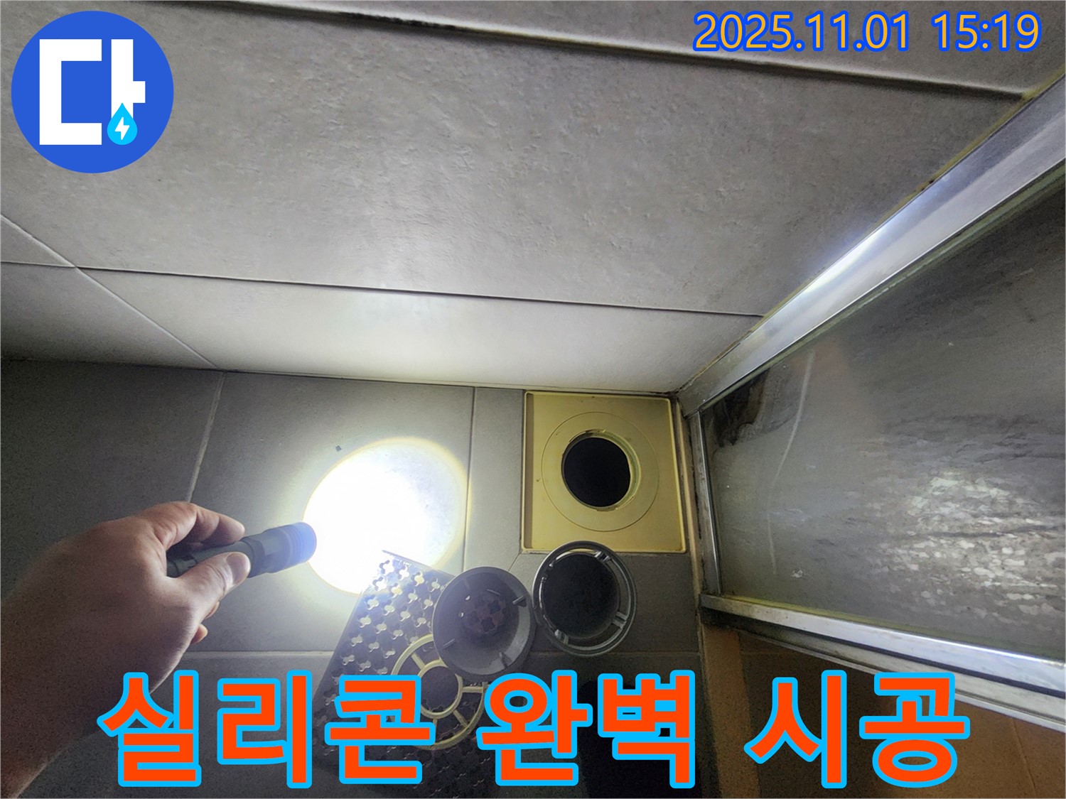 샤워실 배수구 주변을 실리콘으로 완벽하게 시공하고 있습니다 - 꼼꼼한 시공으로 누수를 완벽 차단.