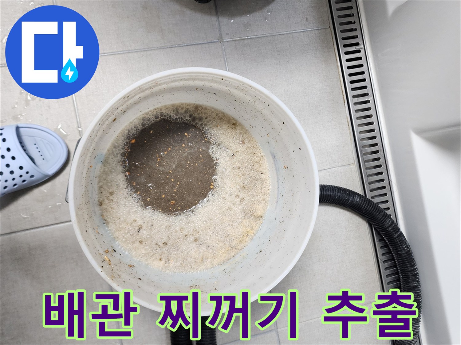 양동이 속의 탁한 물과 검은색 유연 호스