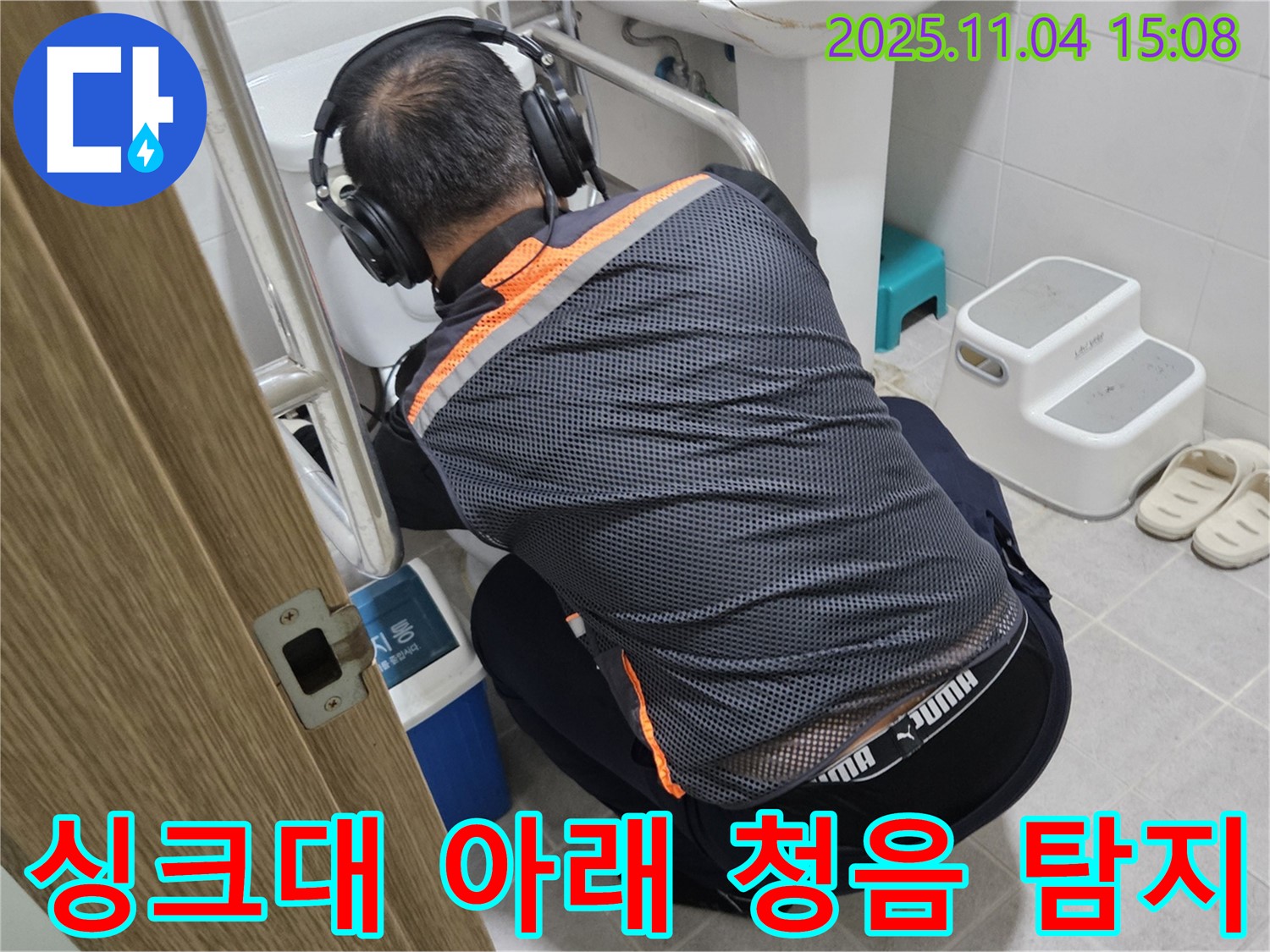 누수 전문가가 싱크대 아래에서 청음 탐지 장비를 사용하여 누수 위치를 찾고 있습니다 - 꼼꼼한 점검으로 숨은 누수까지 찾아냅니다.