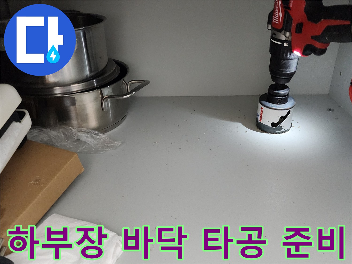 전동 드릴과 홀쏘가 싱크대 하부 선반에 놓인 모습