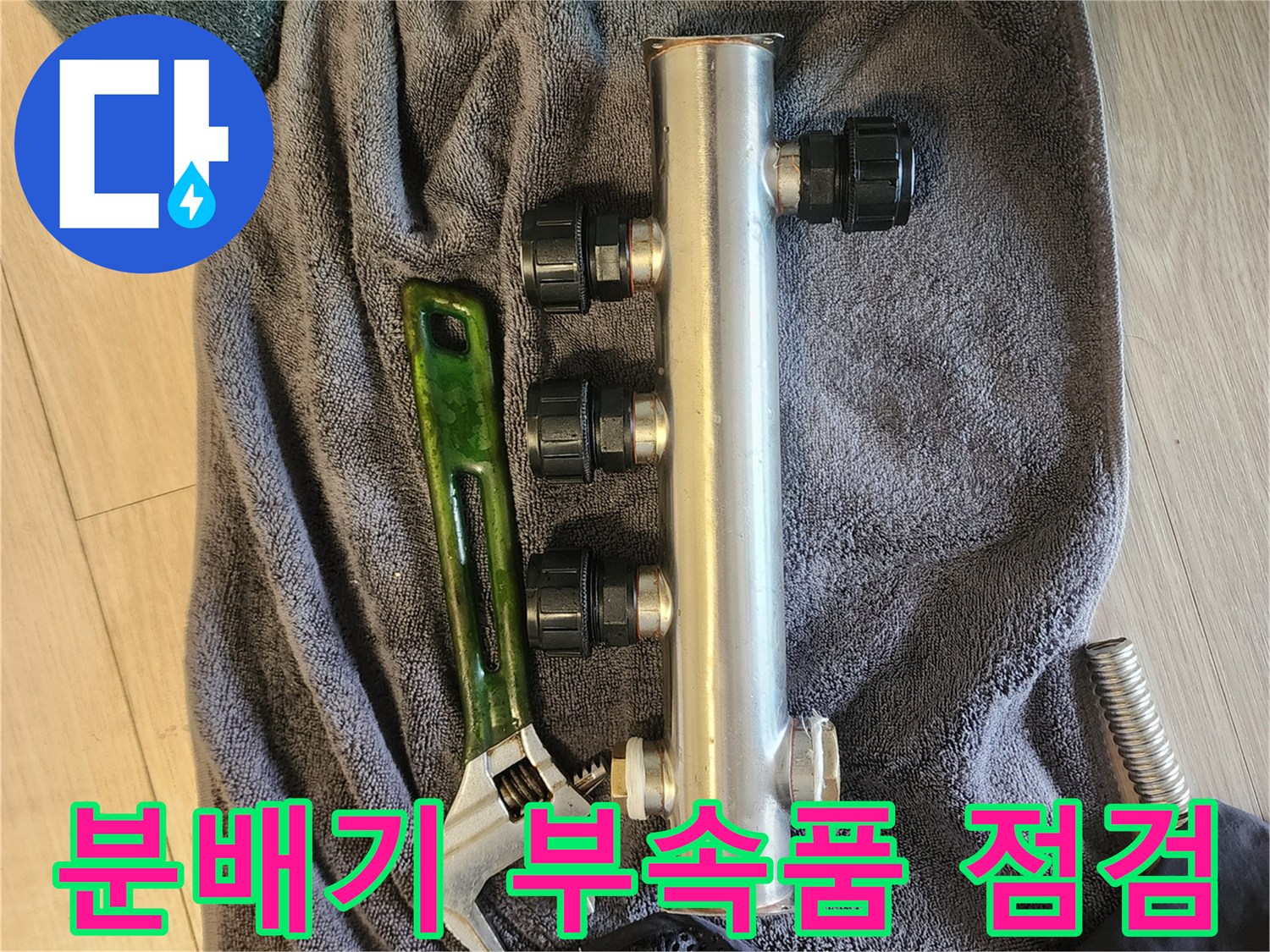 점검 중인 스테인리스 배관 분배기와 몽키 스패너