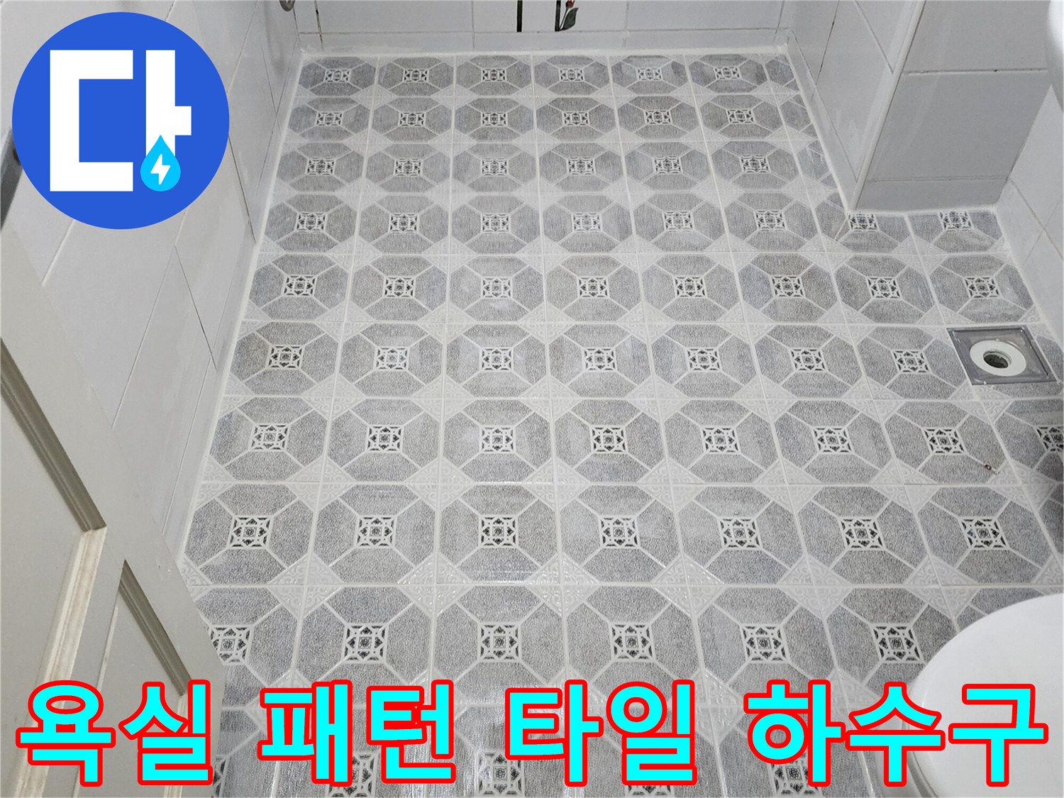 기하학적 무늬의 욕실 타일과 중앙 배수구 모습