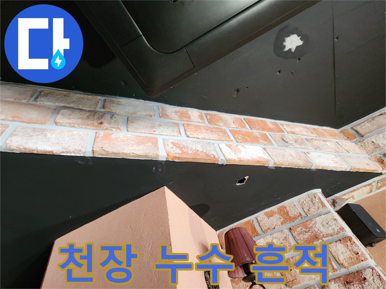 검은색 천장재와 벽돌 사이의 하얀색 물샘 자국