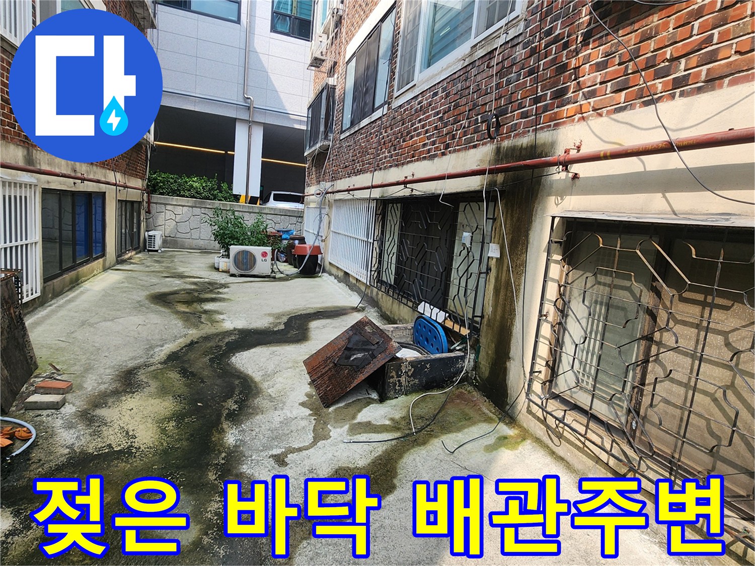 배관 하단부의 젖은 콘크리트와 습기 흔적