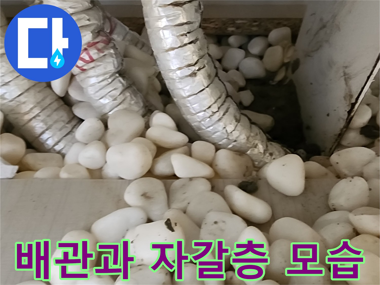 자갈로 채워진 바닥 하부 배관의 상세 사진입니다.