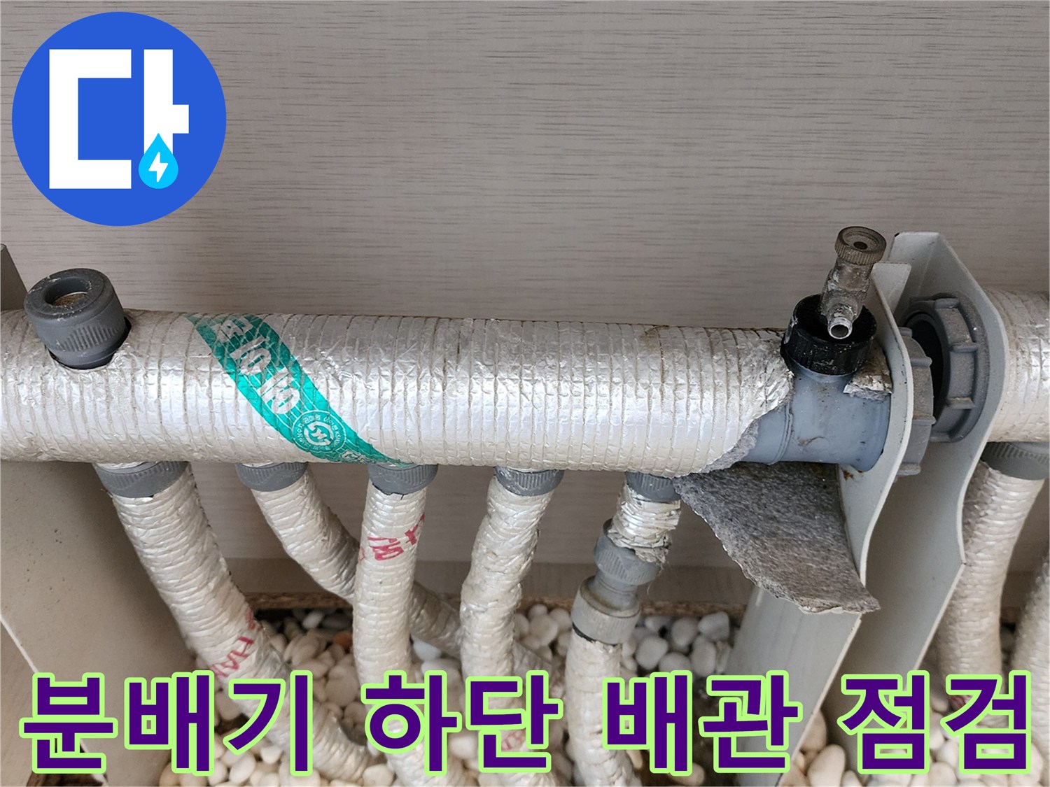 흰 자갈 위에 노출된 분배기 연결 배관의 모습
