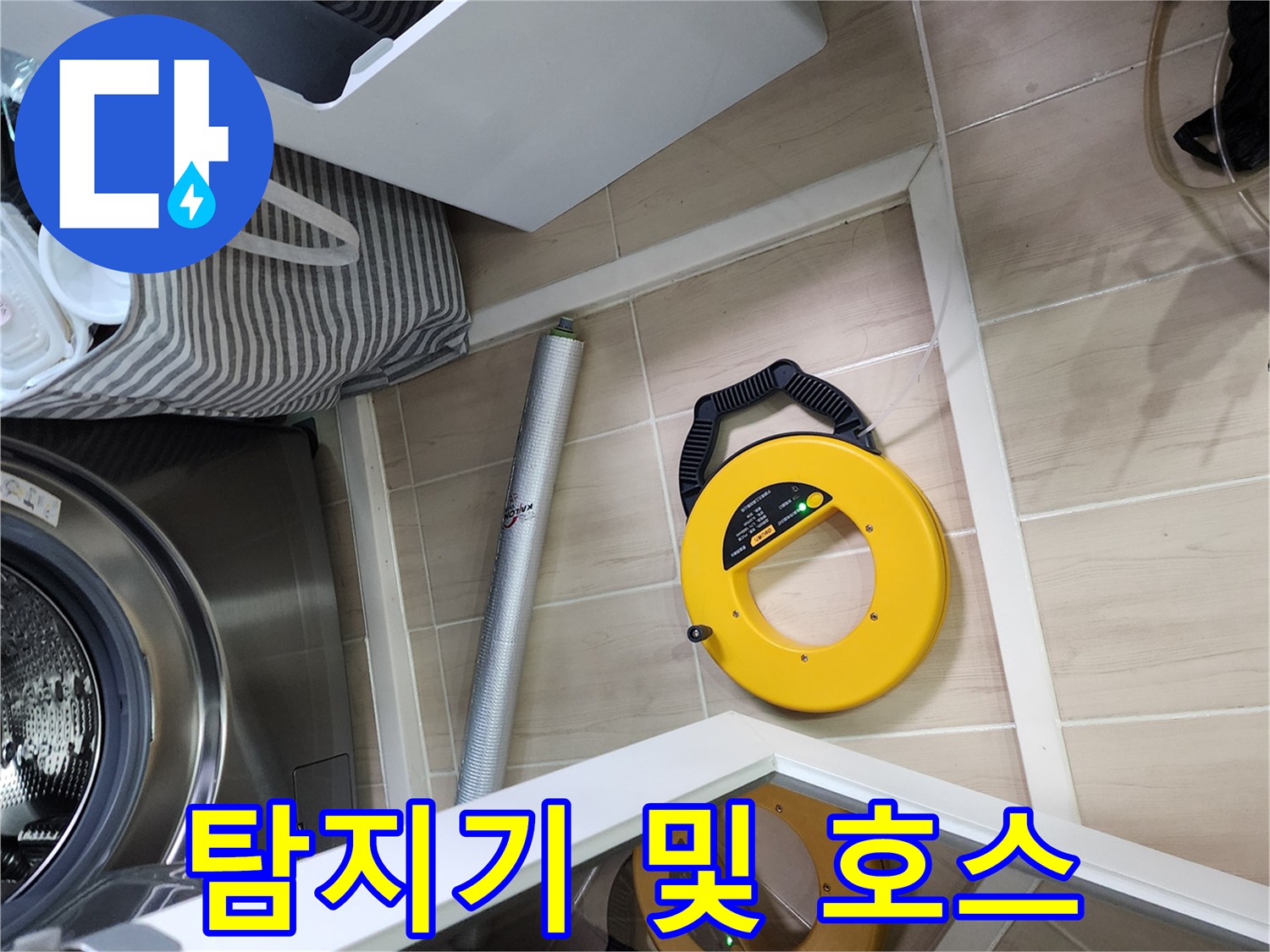세탁기 하단에 놓인 노란색 탐지기와 연결 호스