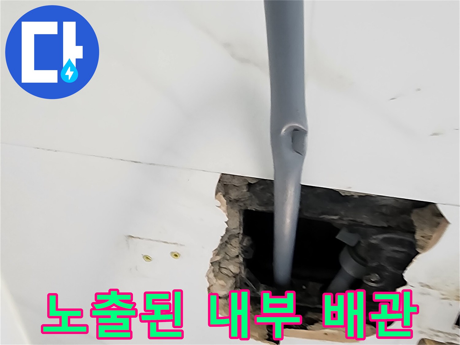 타일을 파낸 자리에 드러난 회색 배관과 흙더미