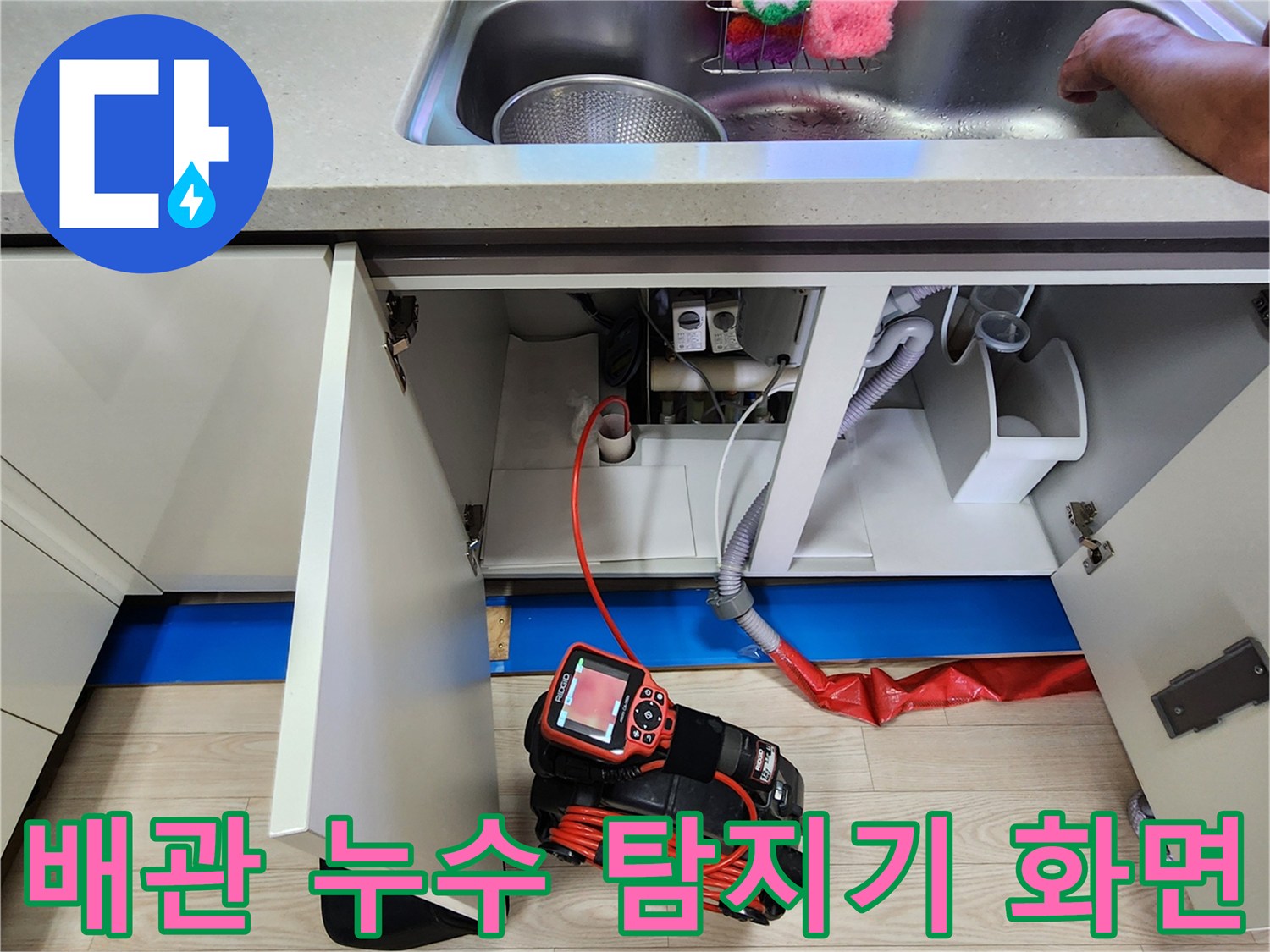 싱크대 하부장 배관에 연결된 가스식 탐지 장비와 호스