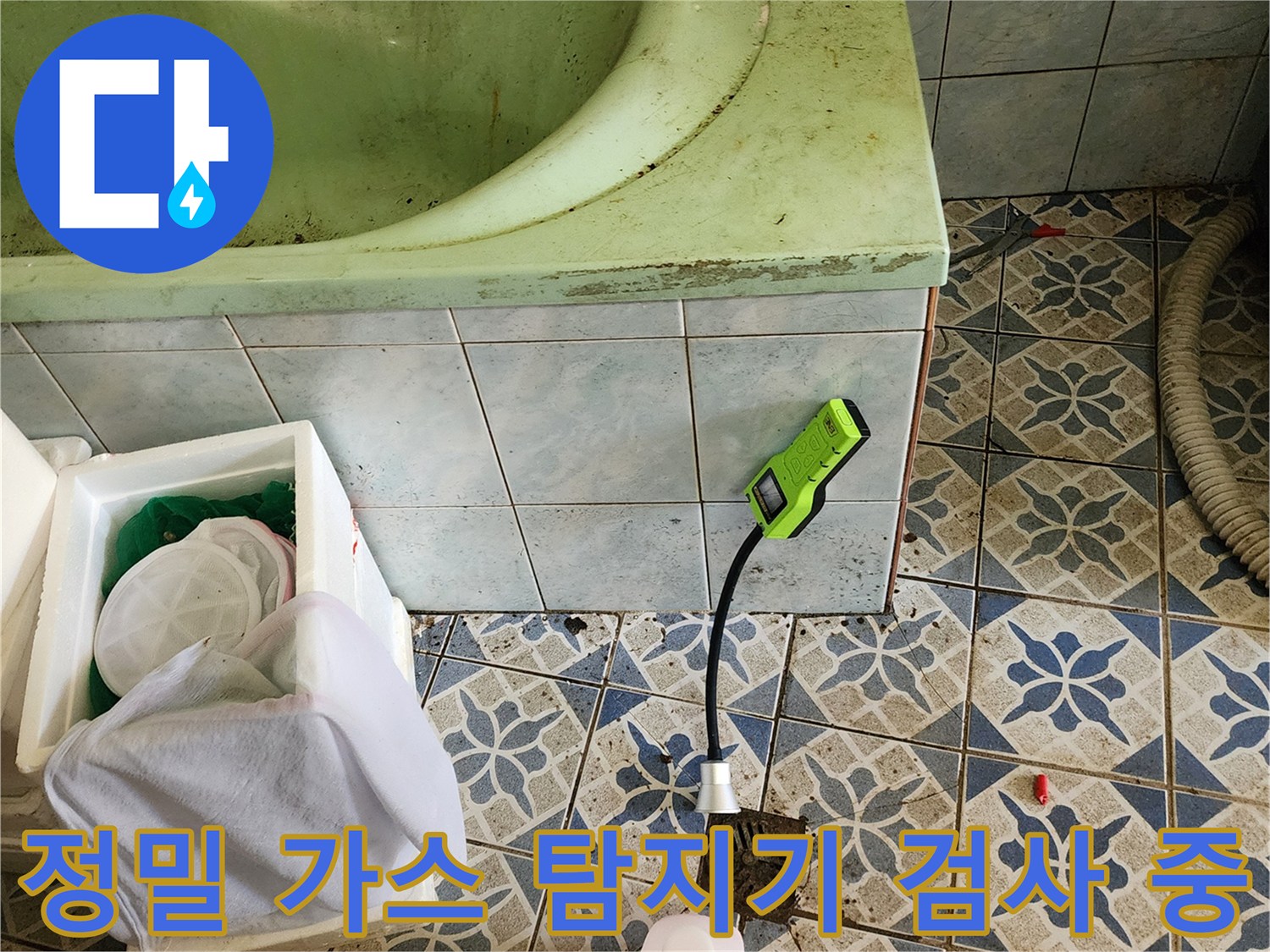 타일 바닥에 놓인 가스 탐지기와 점검용 소품들