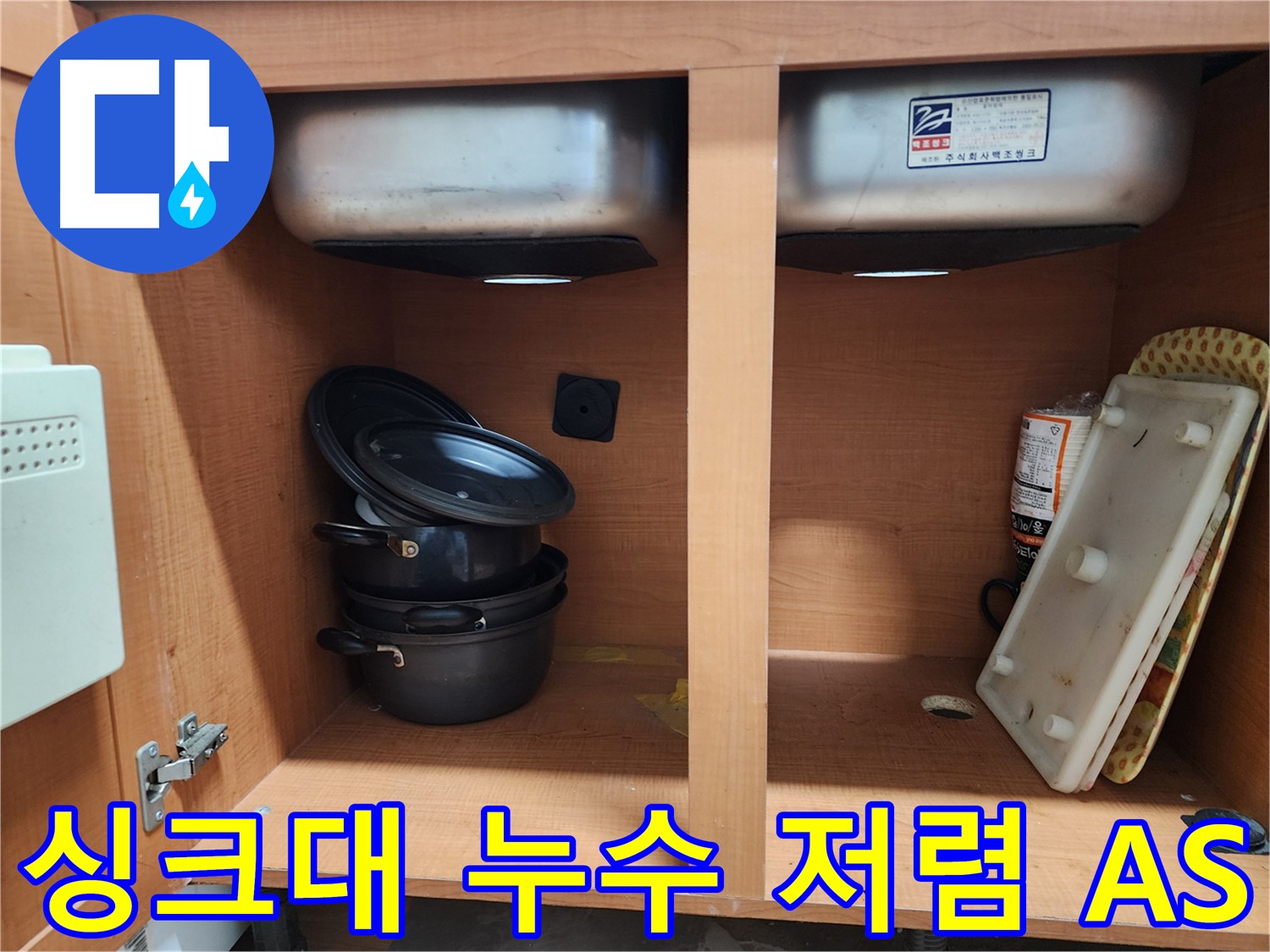 싱크대 하부장 내부 - 누수 원인을 찾기 위해 집중하고 있습니다.
