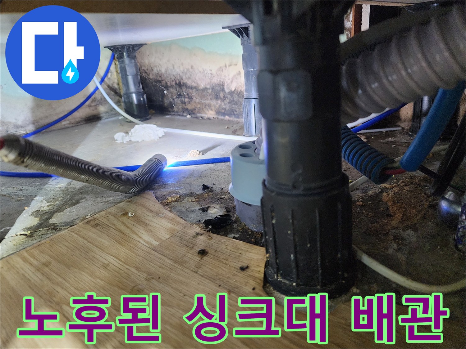 물기가 맺힌 주방 배수 호스와 젖은 바닥 마감재