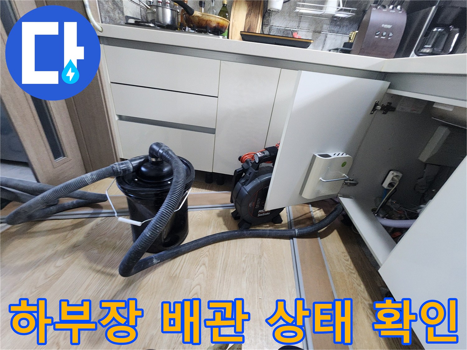 싱크대 밑 공간에 설치된 흡입 장비와 연결 배관의 모습