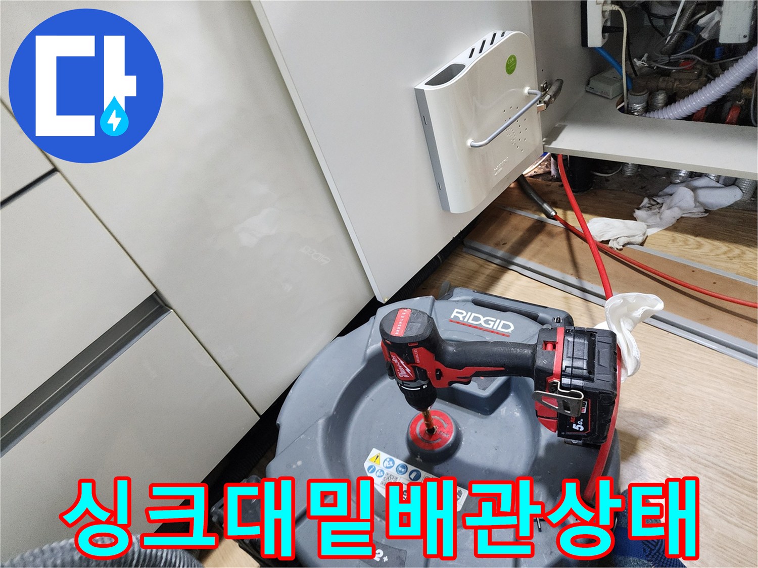 싱크대 아래쪽 어두운 공간에 배치된 배관 확인용 장비들입니다.