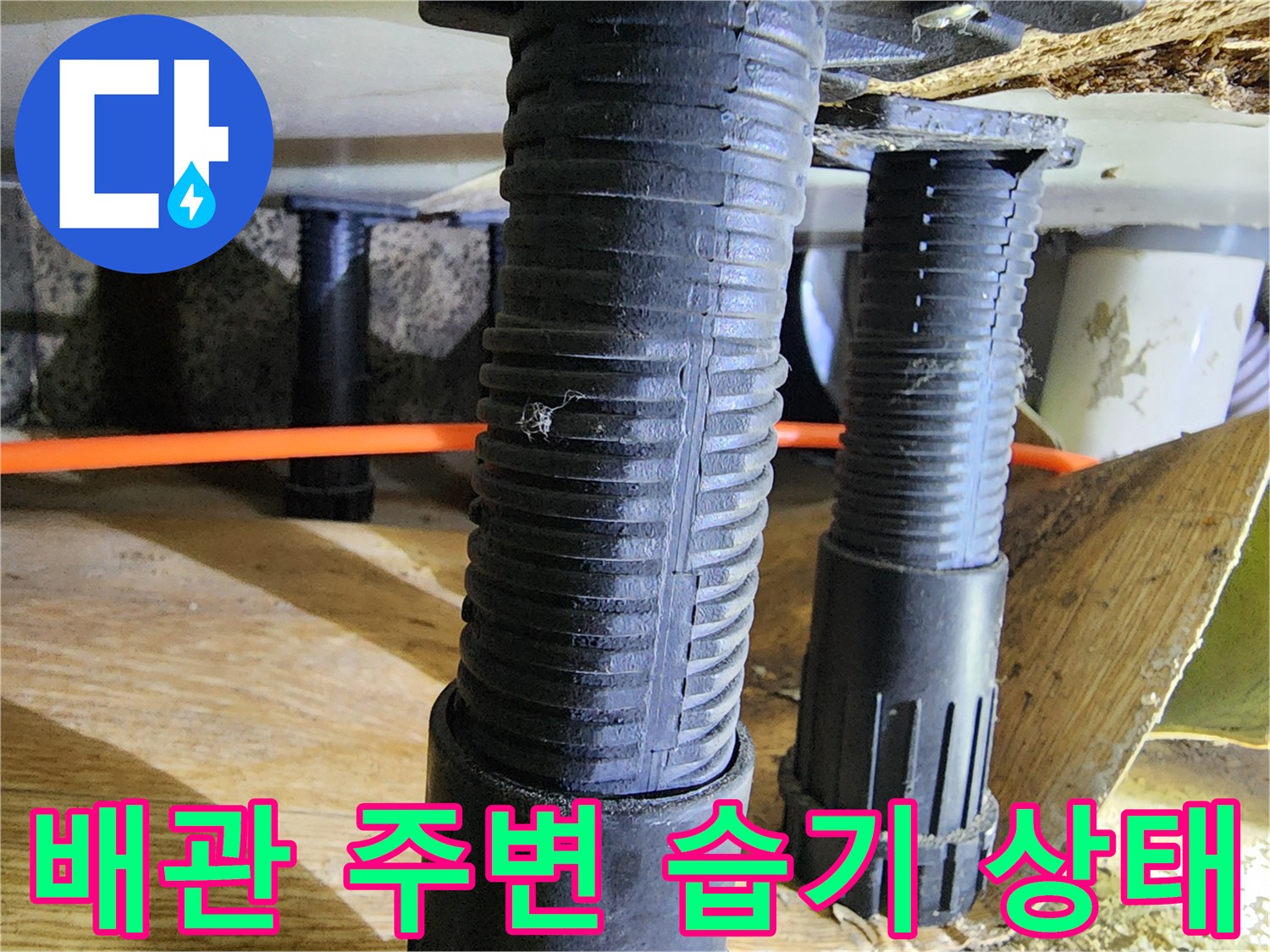 주황색 배관과 검은색 지지대 주변의 습한 환경