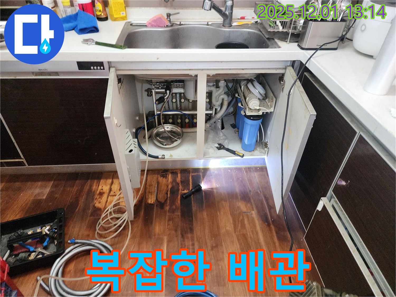 복잡한 구조의 언더싱크 정수기 배관 - 좁은 공간에 복잡하게 얽힌 배관 속에서 누수 지점을 찾고 있습니다.