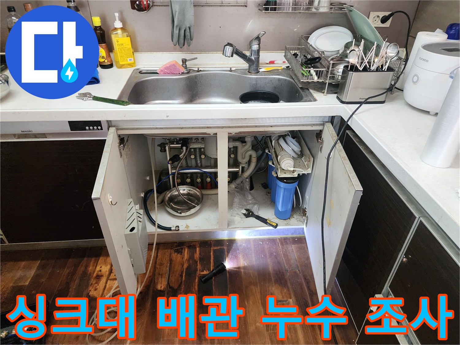 손전등으로-비춘-싱크대-하부-배관-연결부