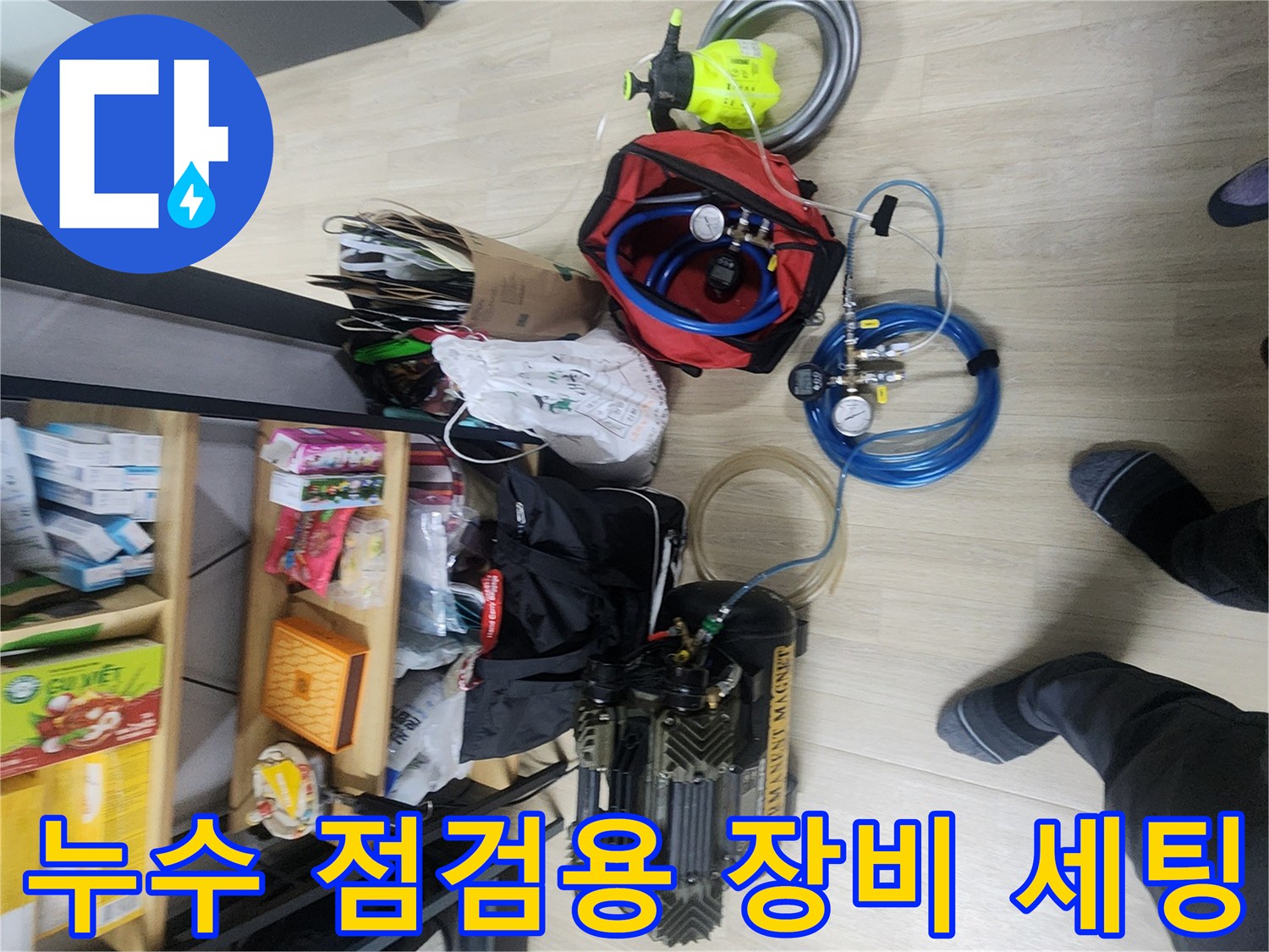 바닥에 펼쳐진 파란색 호스와 가스식 탐지기 및 공압 장치