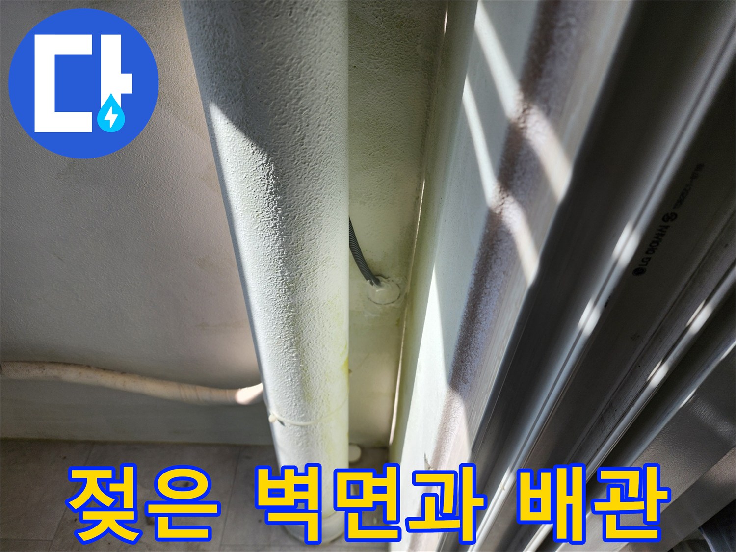 배관 하단부의 젖은 흔적과 벽지 변색 상태