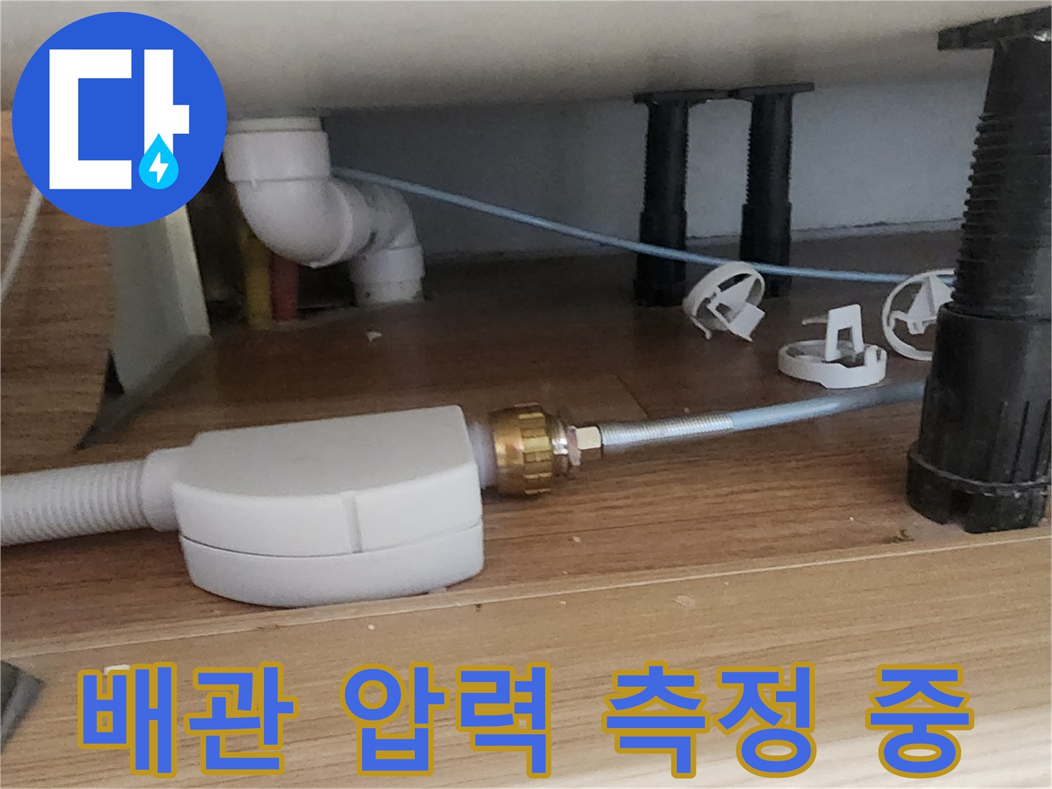 싱크대 아래 배관에 연결된 공압 테스트 장비 상세 모습