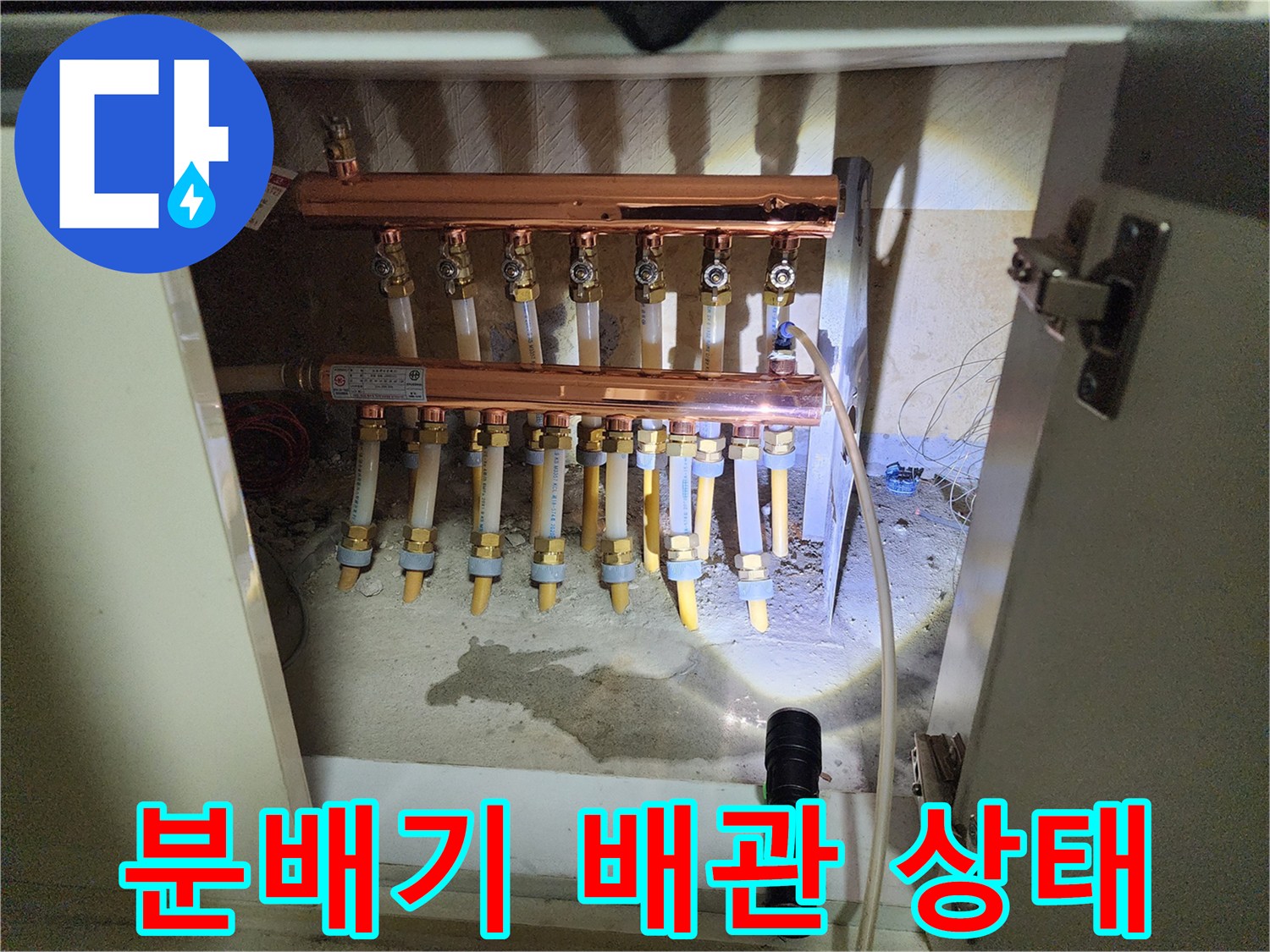 싱크대 하부에 노출된 난방 분배기 구조