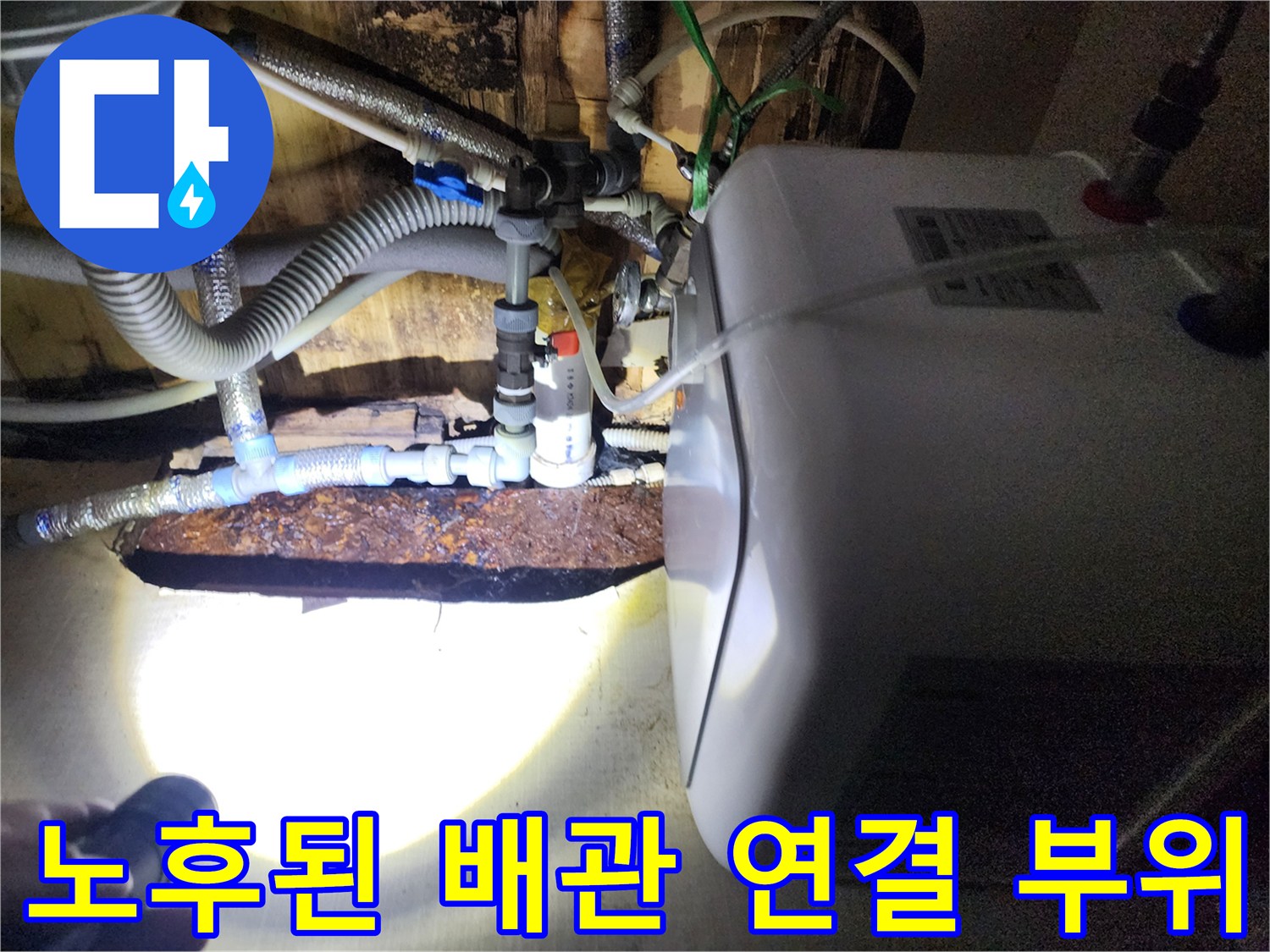 온수기 하단 급수 호스와 부식된 금속 밸브 부위
