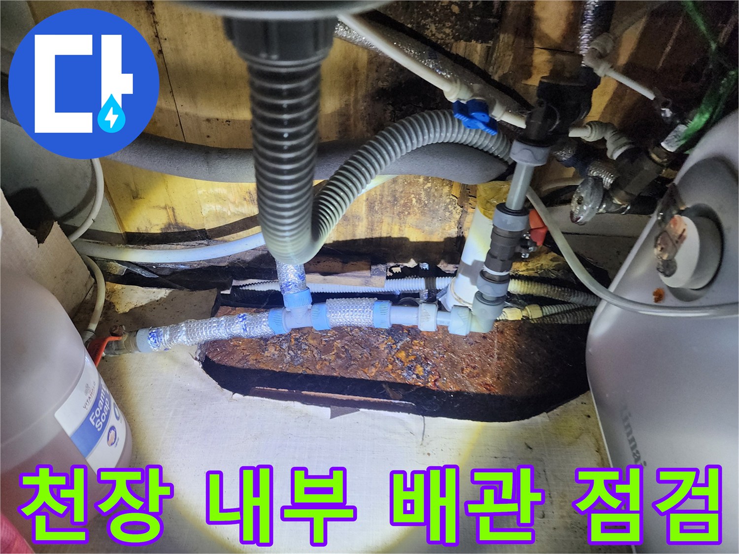 점검등으로 비춘 천장 내부 배관과 얼룩