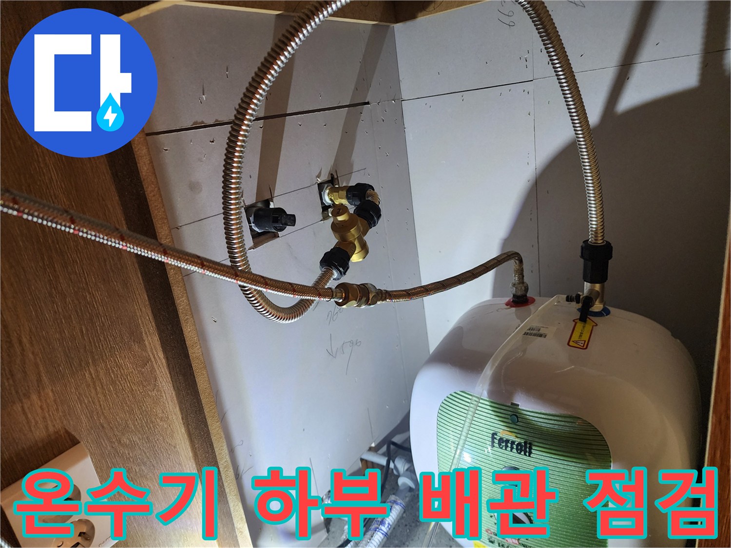 싱크대 아래 설치된-전기 온수기와 급수 배관