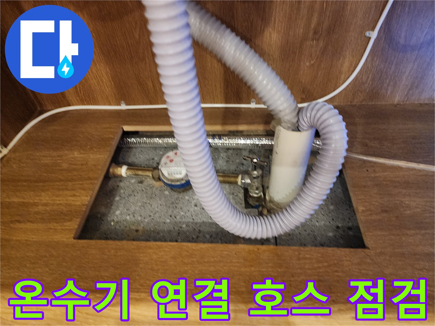 전기 온수기와 유연한 배관이 연결된 하부장 내부 모습