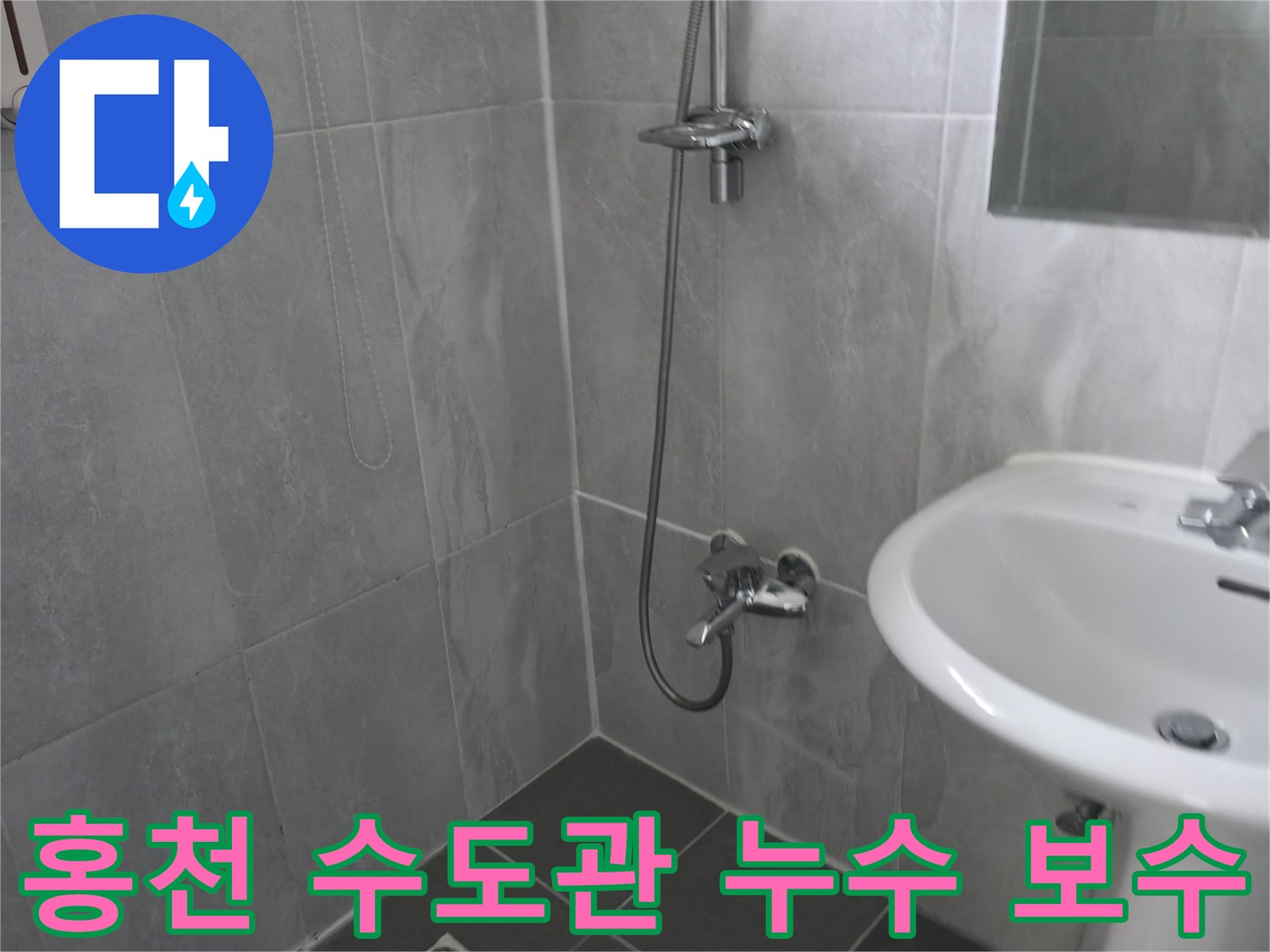 회색 타일로 마감된 욕실의 수도꼭지-샤워기 배관-수도관 누수 점검을 위한 현장 사진