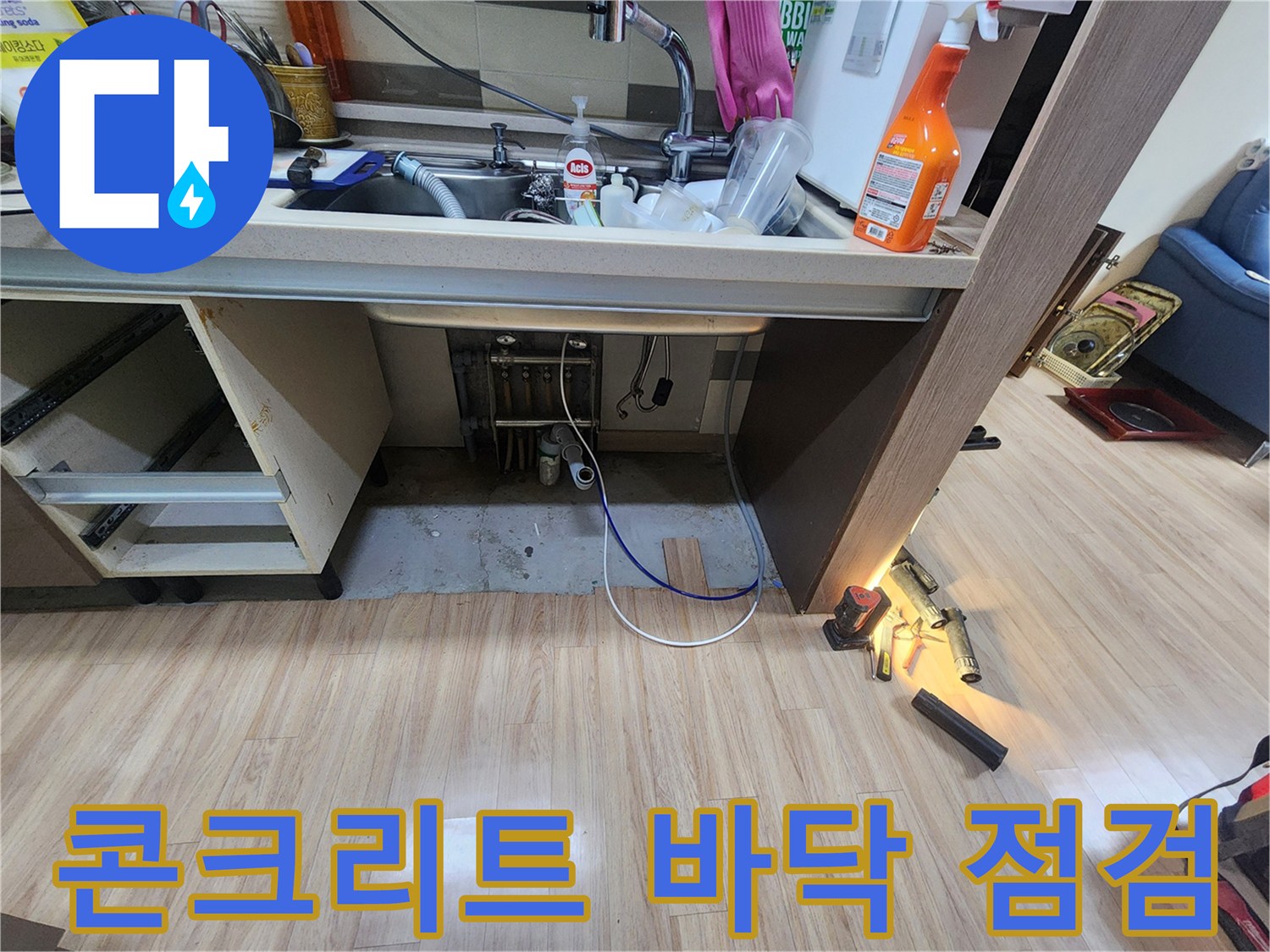싱크대-아래-노출된-콘크리트-바닥의-습기-및-변색-상태를-점검하며-누수-원인을-파악하는-모습