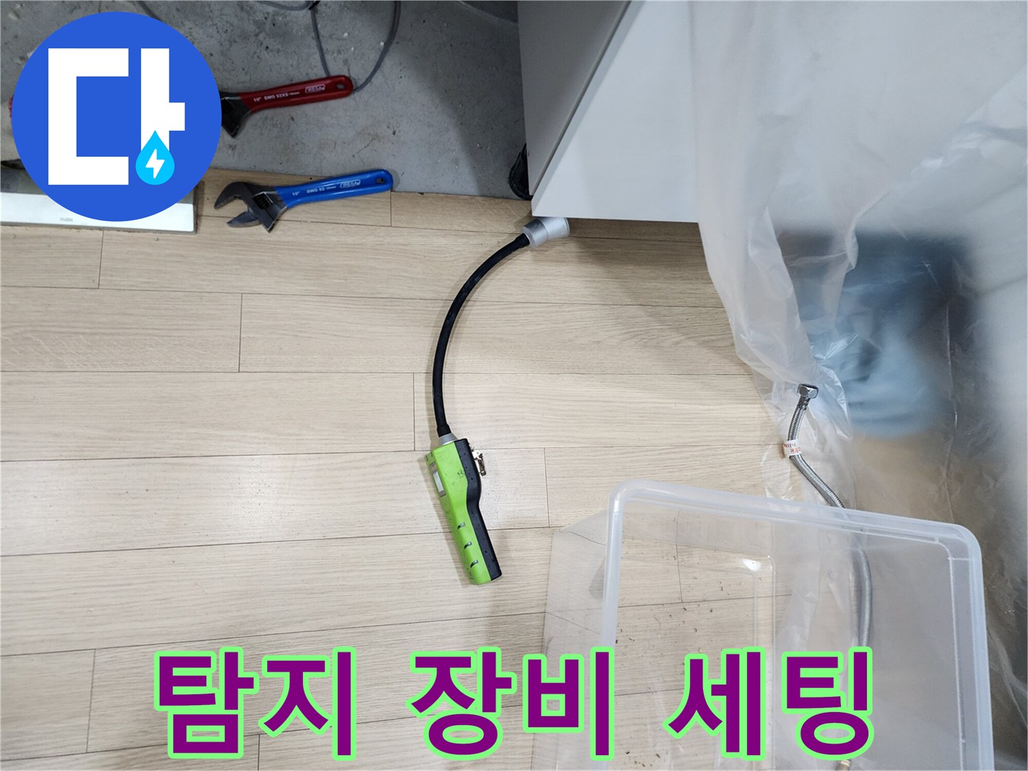 누수 탐지를 위해 싱크대 밑에 배치된 가스 측정 장비와 공구