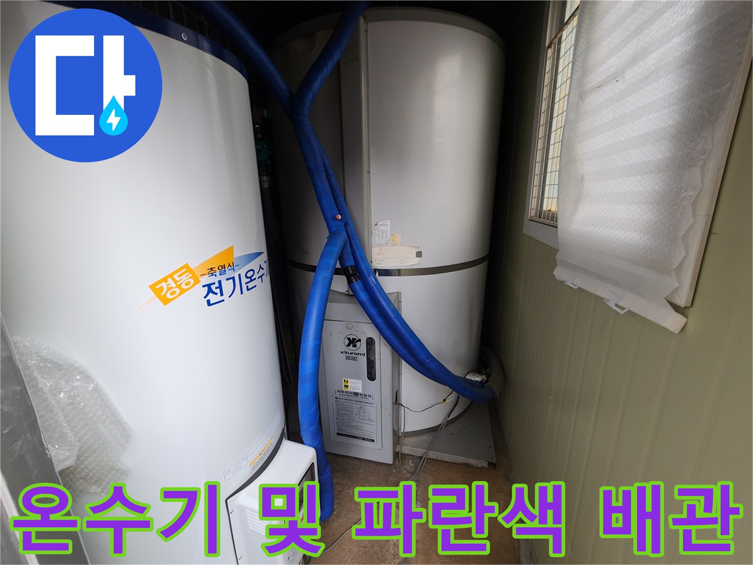 전기 온수 탱크와 하단에 연결된 파란색 보온재 배관의 모습입니다.