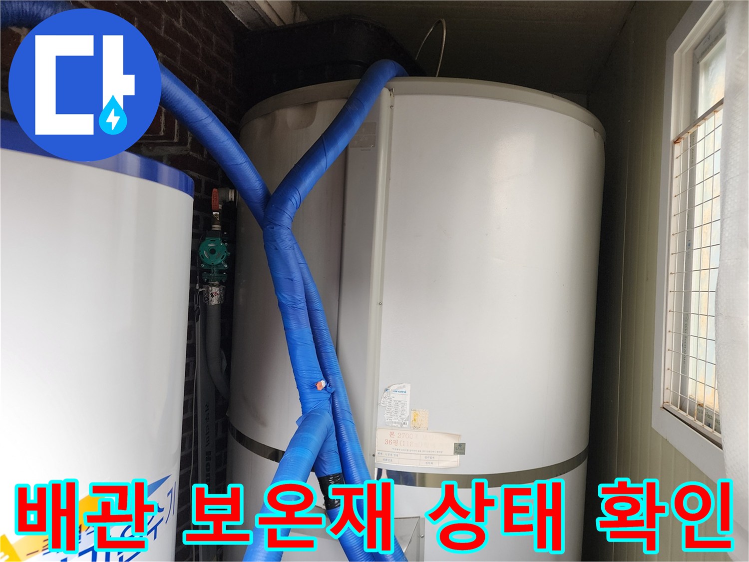 파란색 보온재로 마감된 급수 배관이 대형 온수 탱크에 연결되어 있습니다.