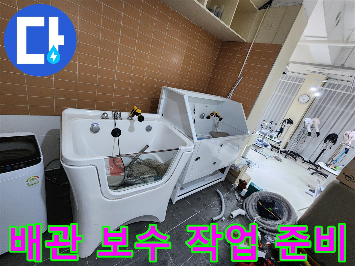 샴푸대 아래 배관 부근에 놓인 공구와 자재들