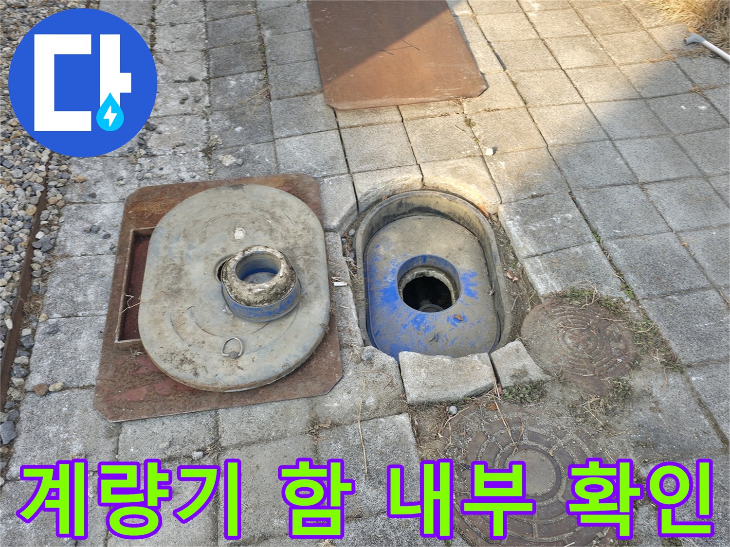 야외 배관시설-계량기함과 맨홀 덮개가 노출된 모습
