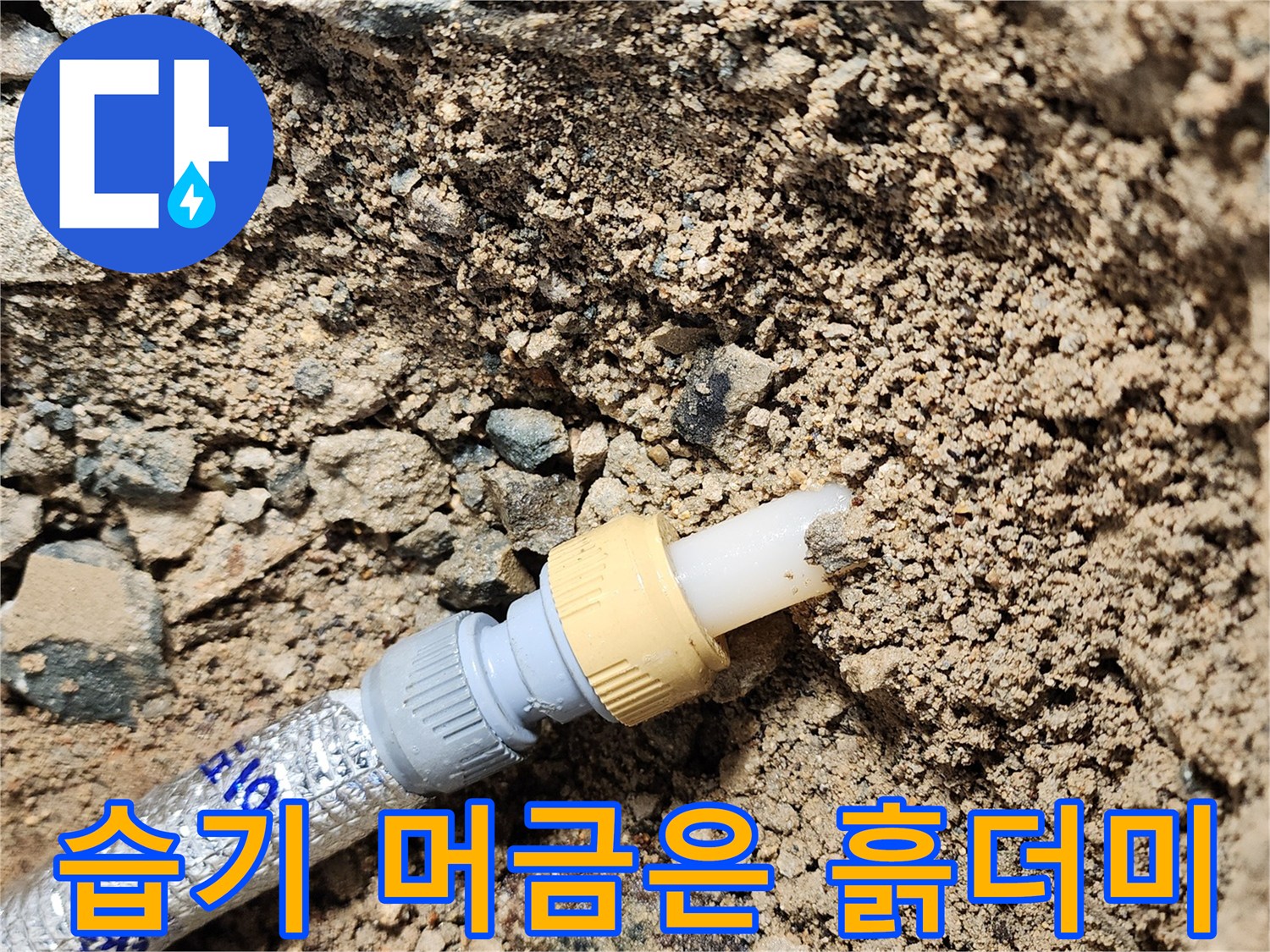 배관 주변의 물에 젖은 흙과 연결 부품 상세 사진