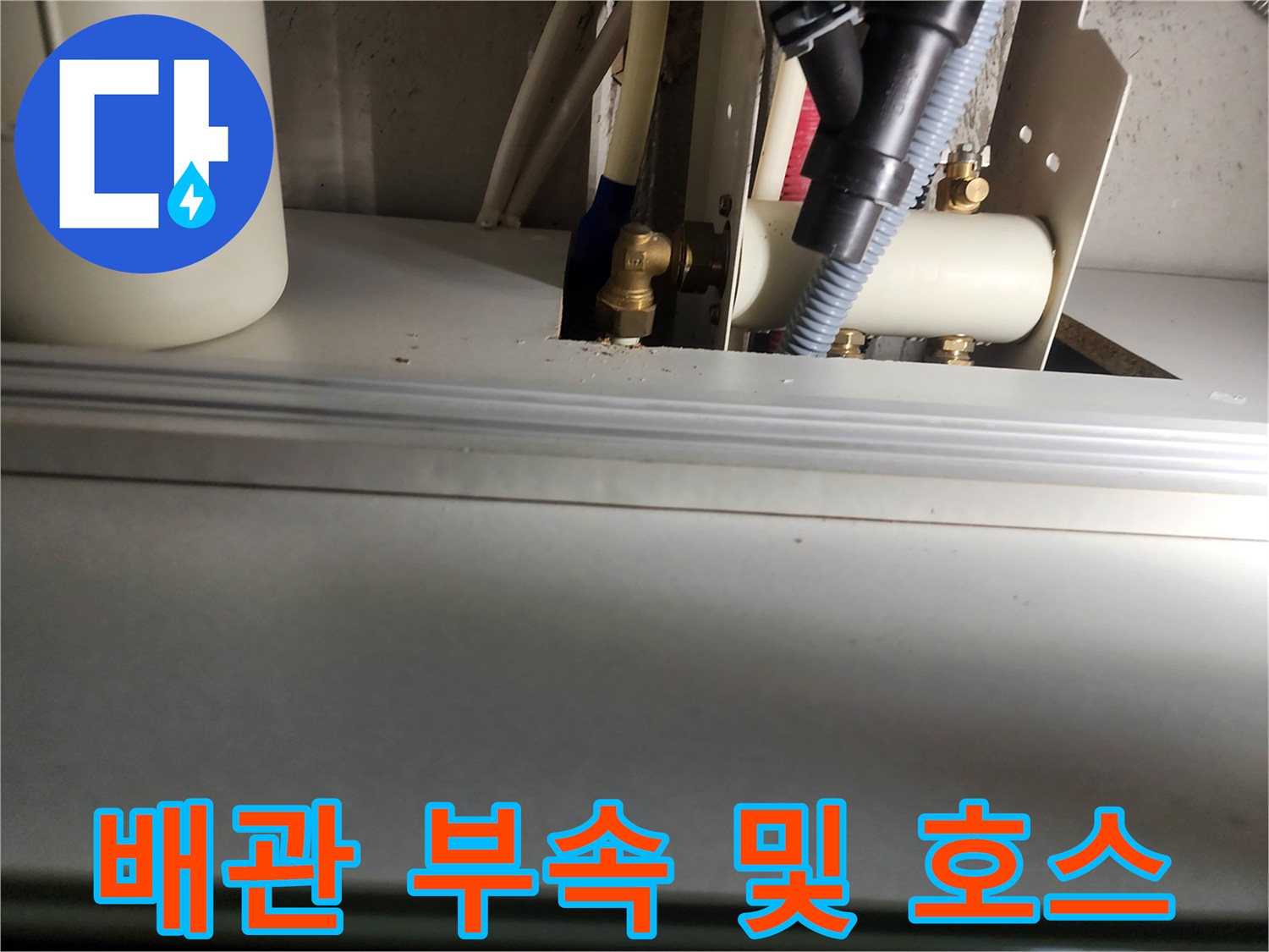 금속 엘보와 급수용 호스가 연결된 배관 구조물 사진