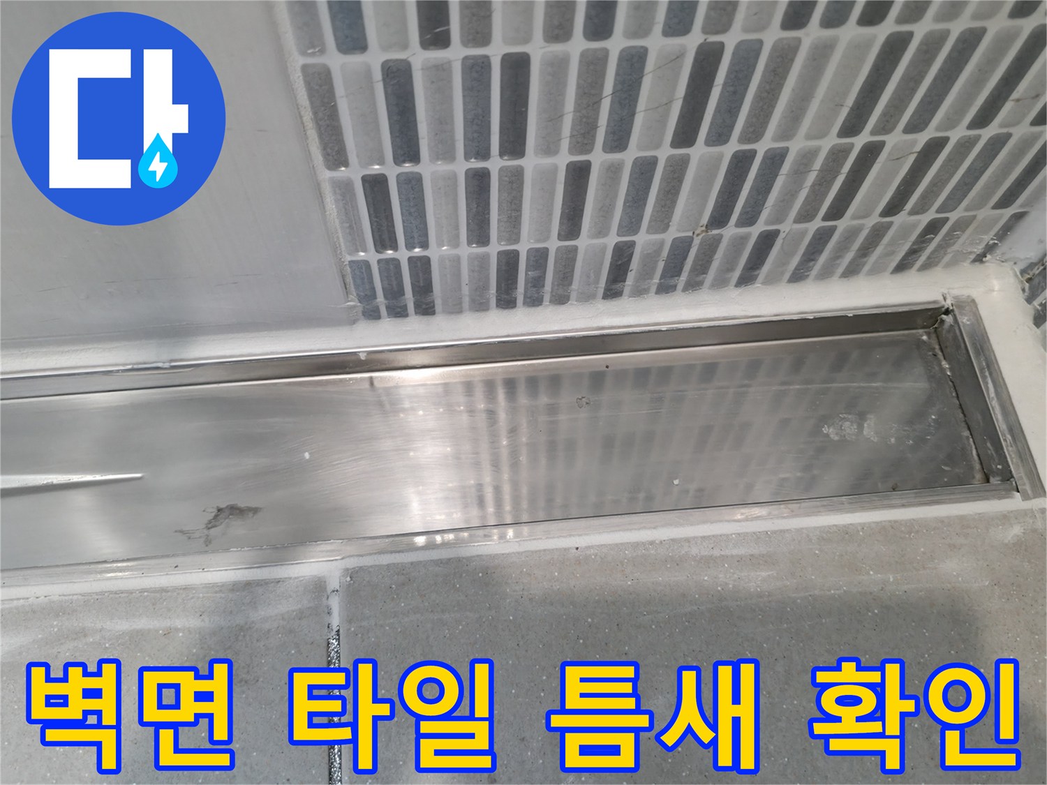 세로형 타일 배열과 스테인리스 배수 트렌치 경계 부위