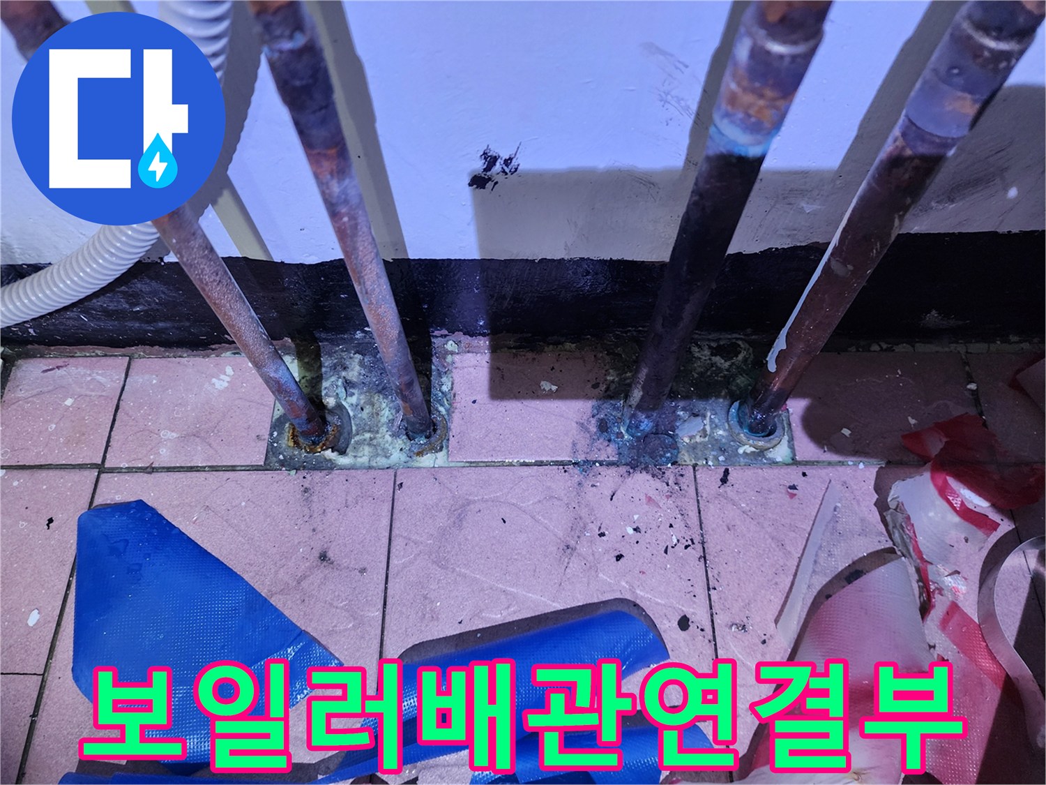 물기가-맺혀있는-동배관과-바닥-타일-연결부