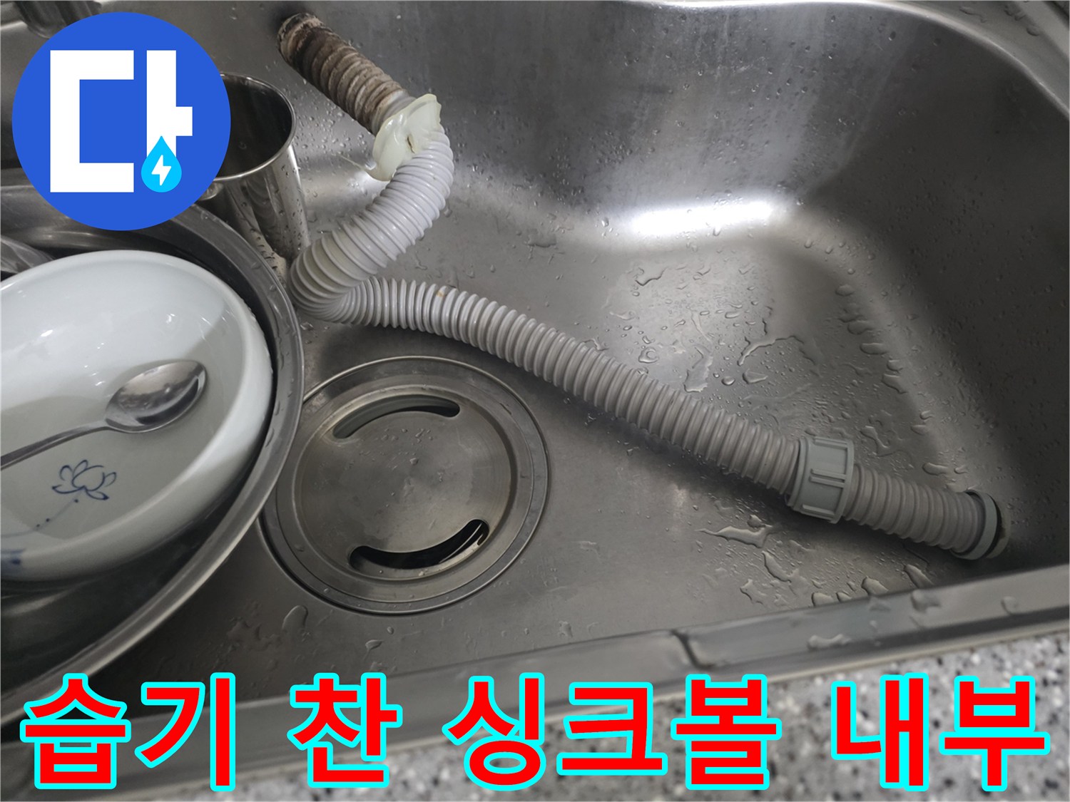 물기가 남아 있는 싱크볼과 연결된 주름 배관