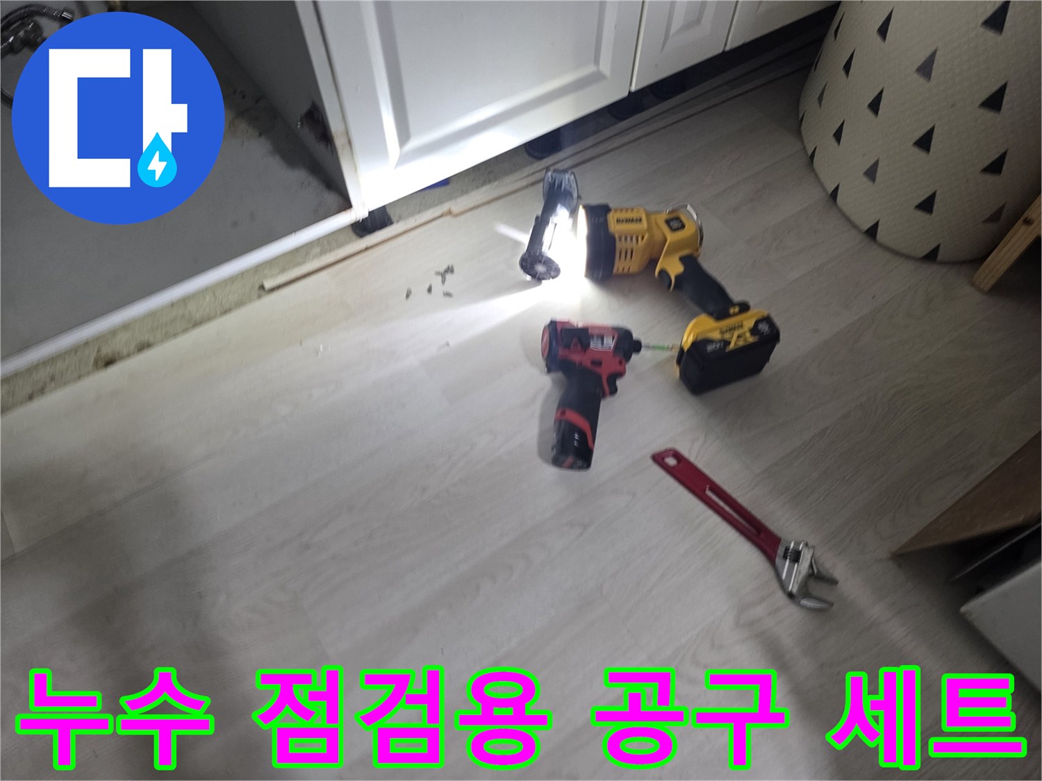 어두운 하부장을 비추는 랜턴과 작업용 렌치