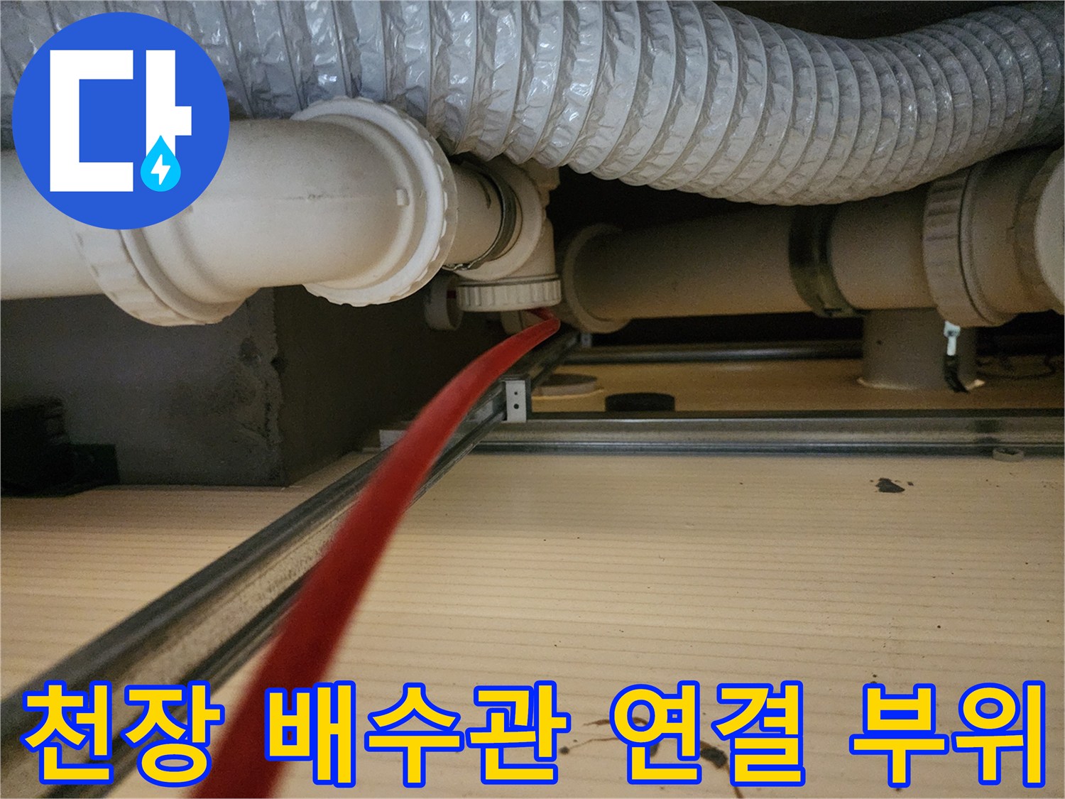 점검구 내부의-하얀색 PVC 배관과 은색 플렉시블 호스