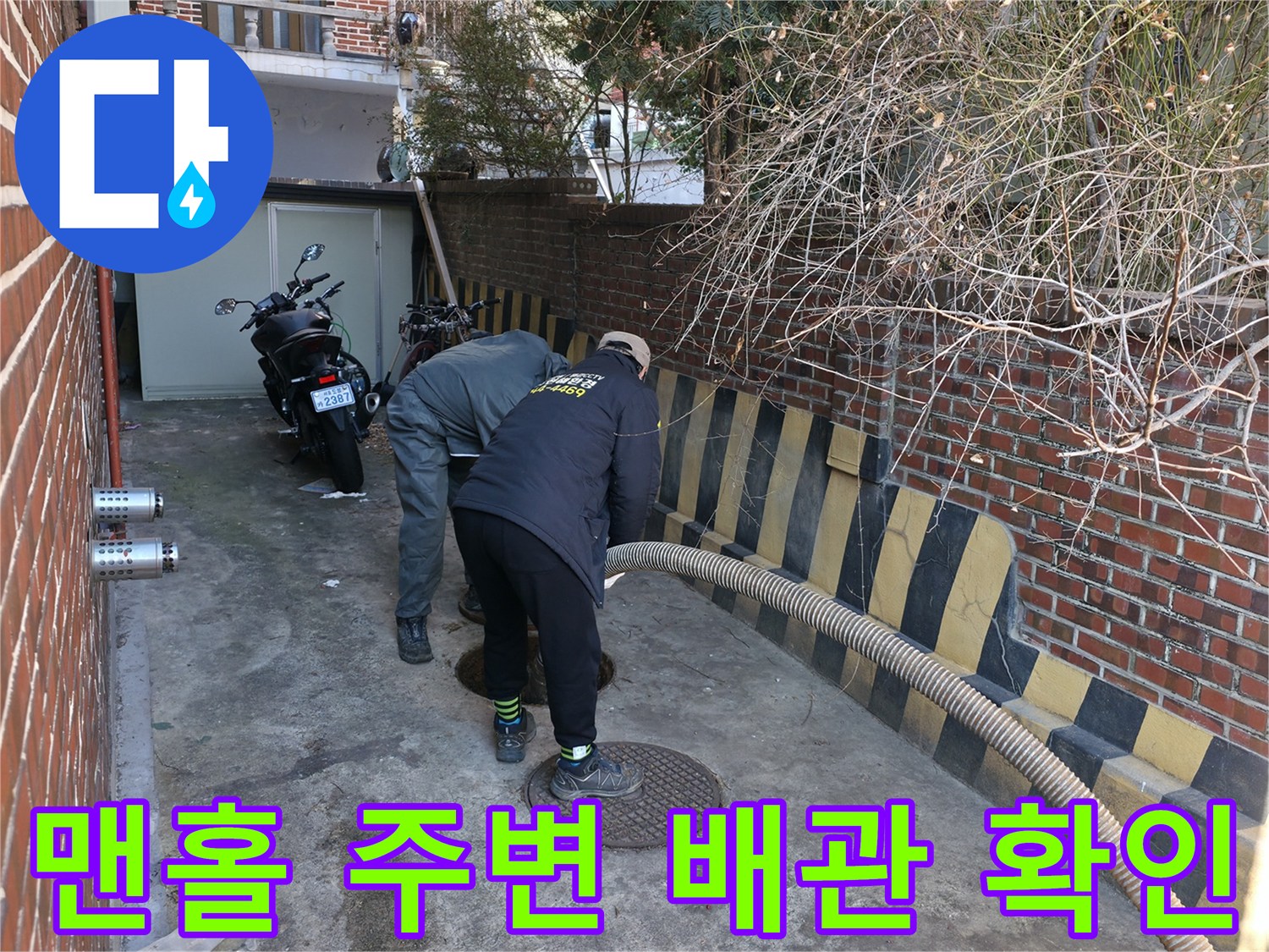 배관 점검을 위해 맨홀 뚜껑 근처를 살피는 엔지니어